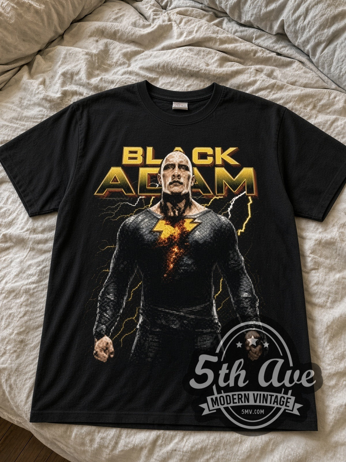 Black Adam black graphic tee laid flat on linen bed