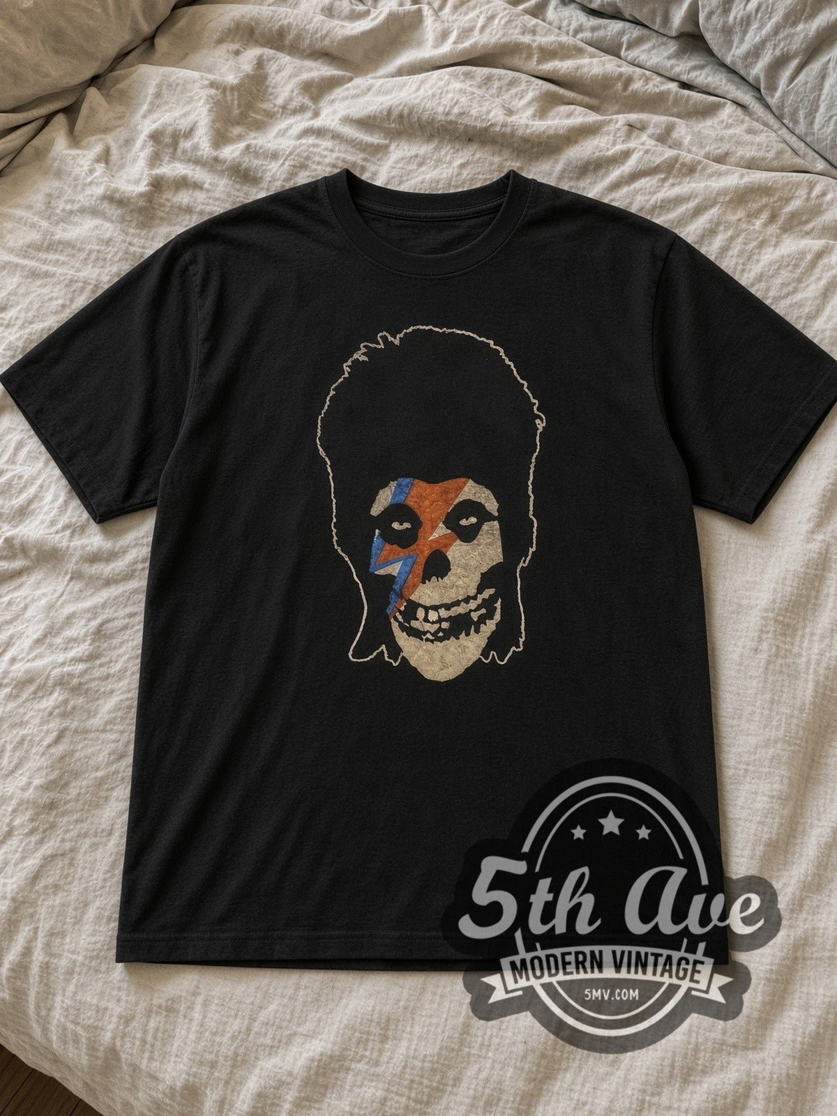Black David Bowie Lightning Bolt Skull Vintage Band T-Shirt laid flat on a linen bed