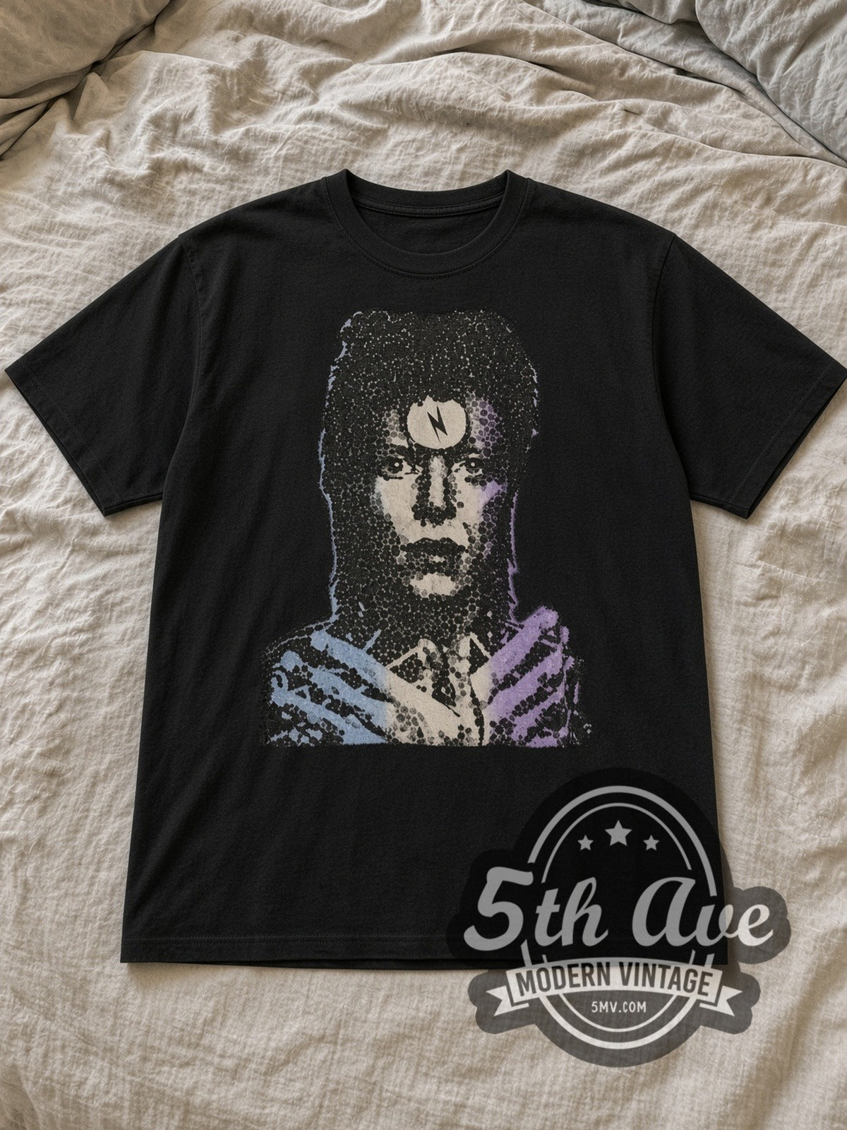 Black David Bowie Enigmatic Resonance Portrait Vintage Band T-Shirt laid flat on a linen bed
