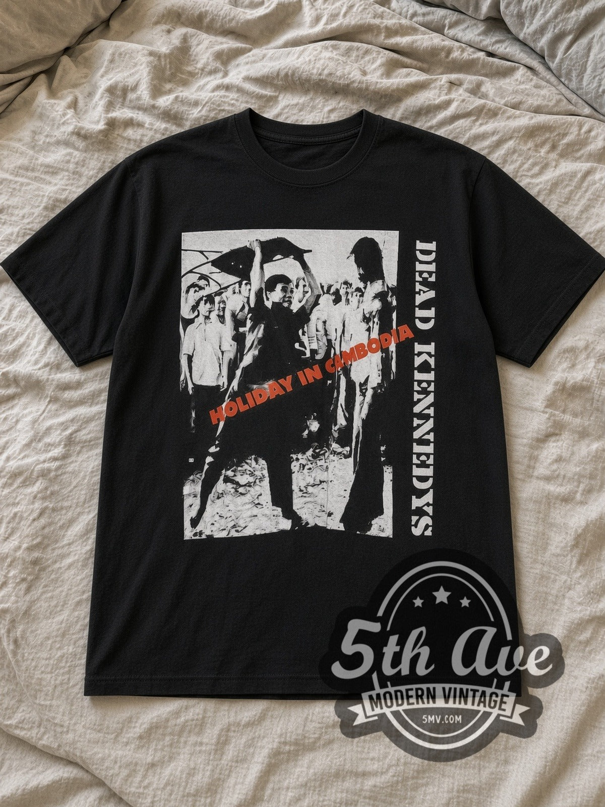 Black Dead Kennedys Holiday in Cambodia Vintage Band T-Shirt laid flat on a linen bed
