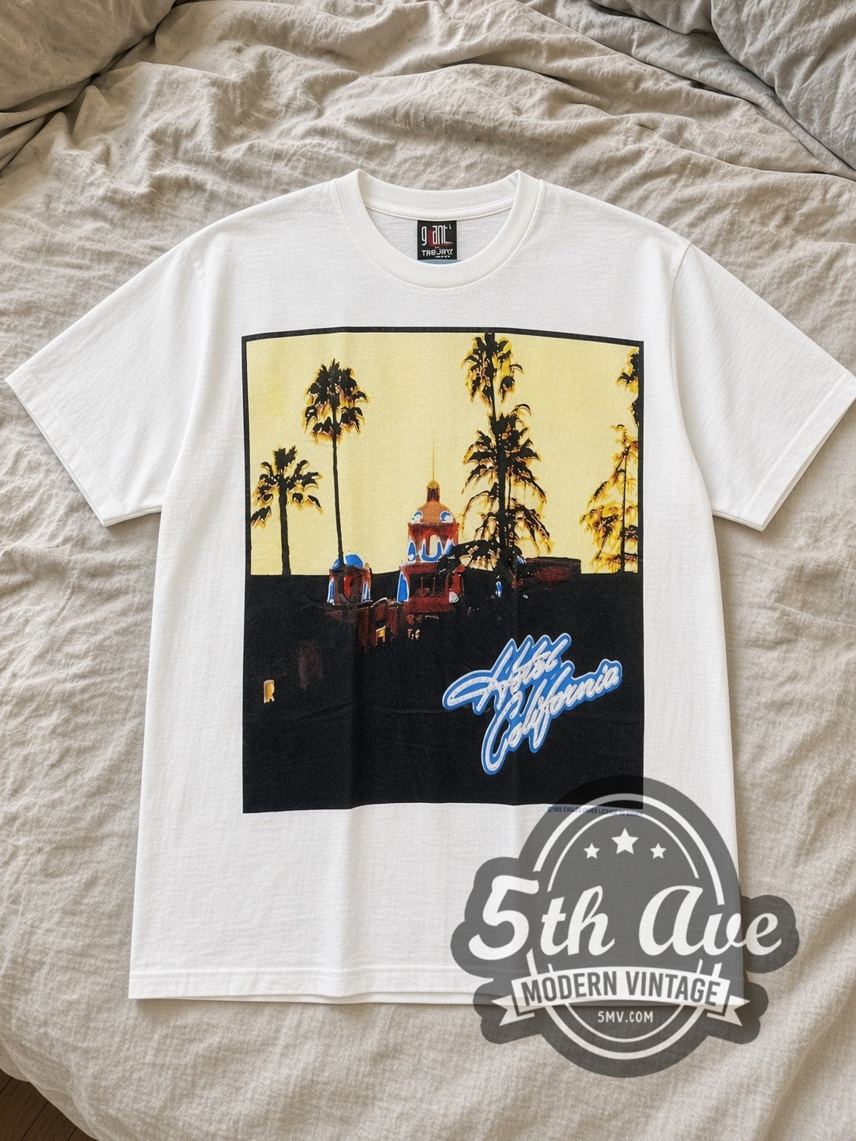 White Eagles Hotel California White Tribute Vintage Band T-Shirt laid flat on a linen bed