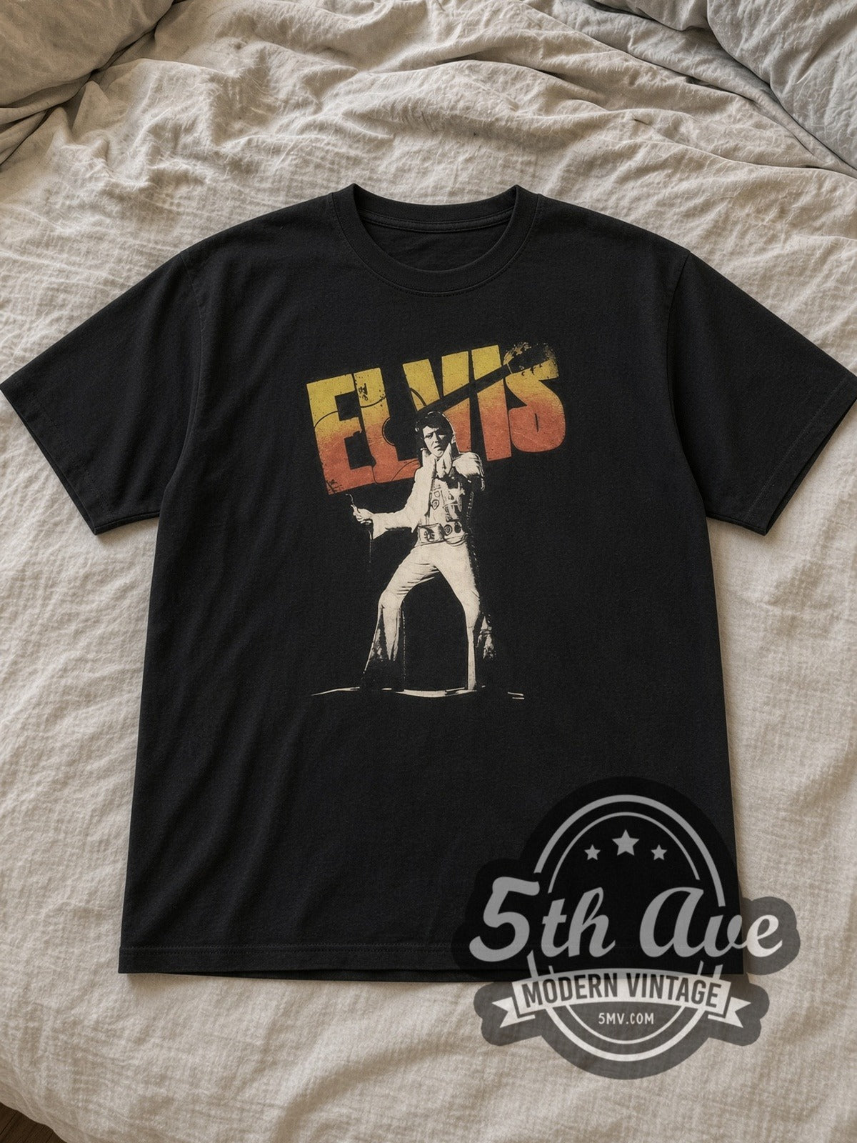 Black Elvis Presley Stage Pose Logo Vintage Band T-Shirt laid flat on a linen bed