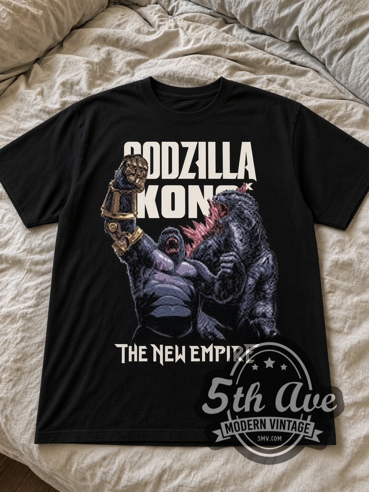 Godzilla x Kong The New Empire black graphic tee laid flat on linen bed