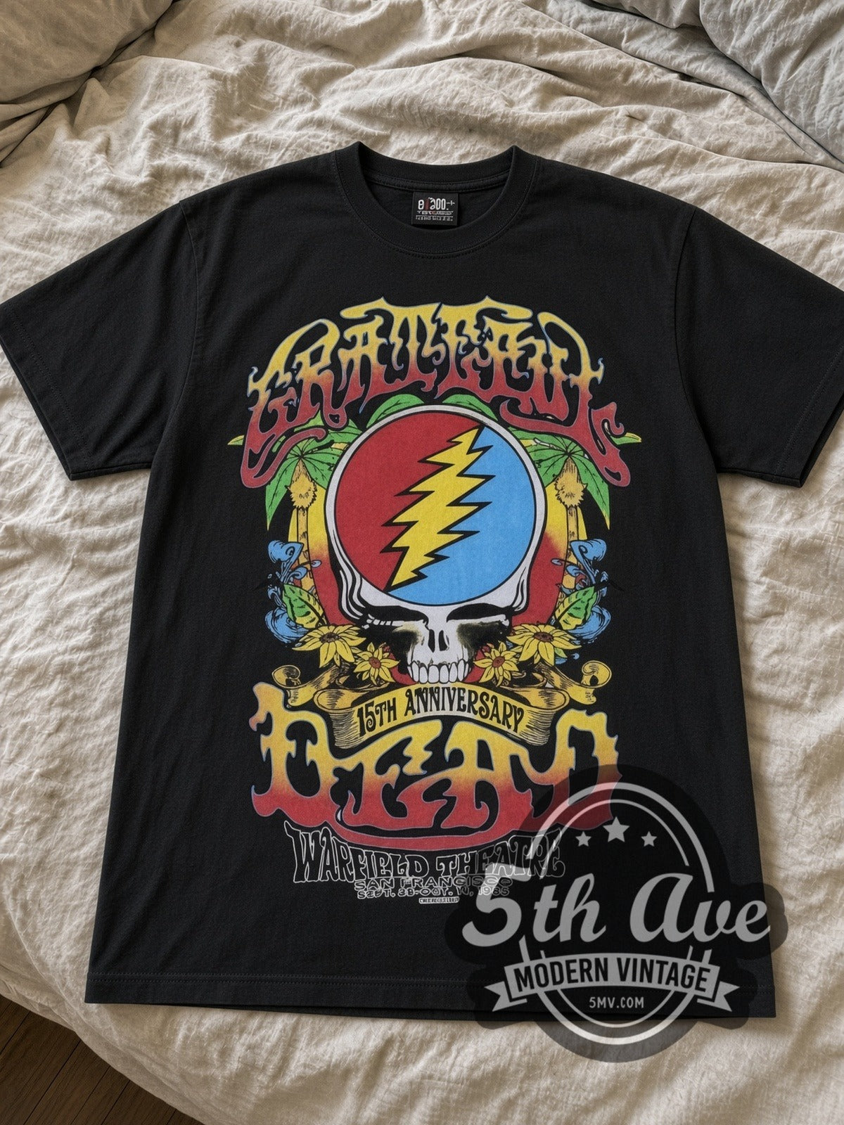 Grateful Dead Steal Your Face & Rose Skeleton Warfield band t-shirt in black laid flat on a bed, front artwork