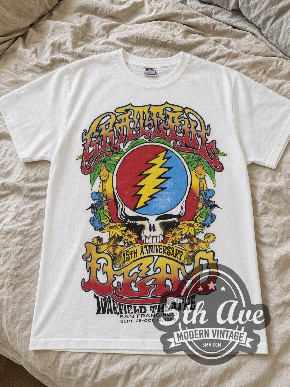 Grateful Dead Steal Your Face & Rose Skeleton Warfield band t-shirt in white laid flat on a bed, front artwork