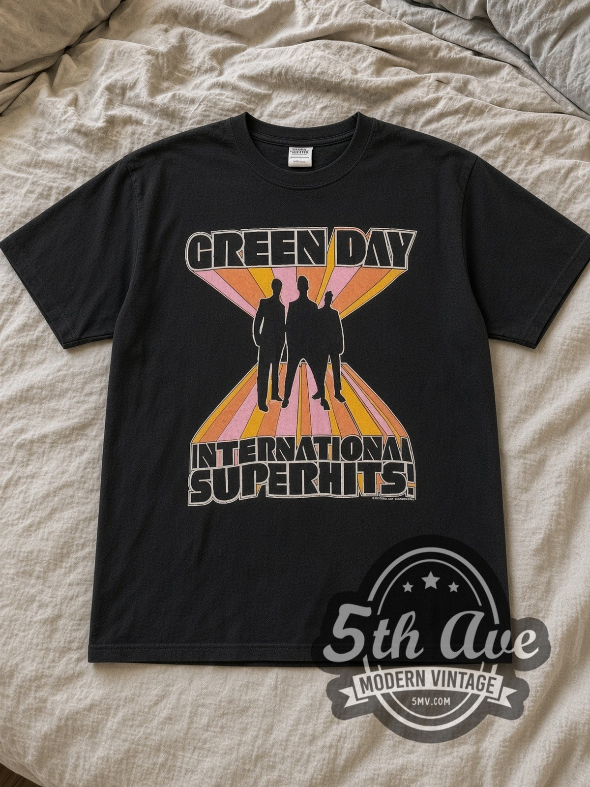 Black Green Day International Superhits Tour Vintage Band T-Shirt laid flat on a linen bed