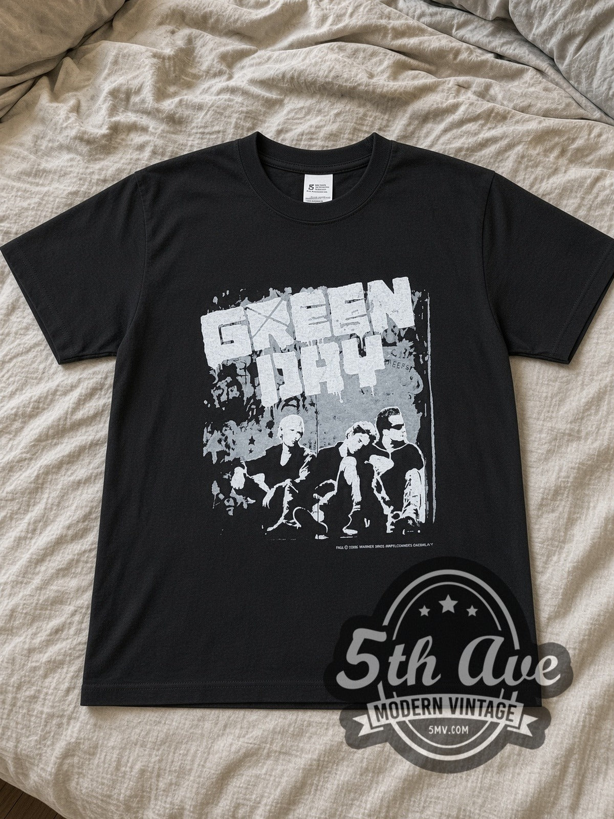 Green Day Tour 1996 Band Photo band t-shirt in black laid flat on a bed, front artwork