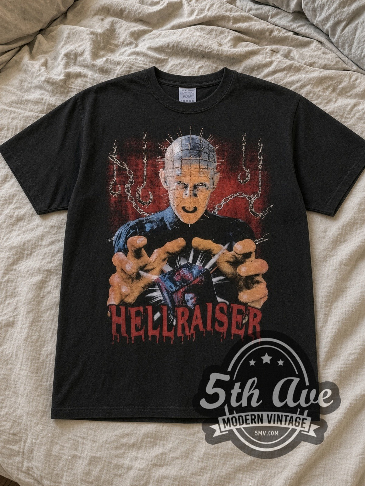 Black Hellraiser Puzzle Box Vintage Movie T-Shirt laid flat on a linen bed