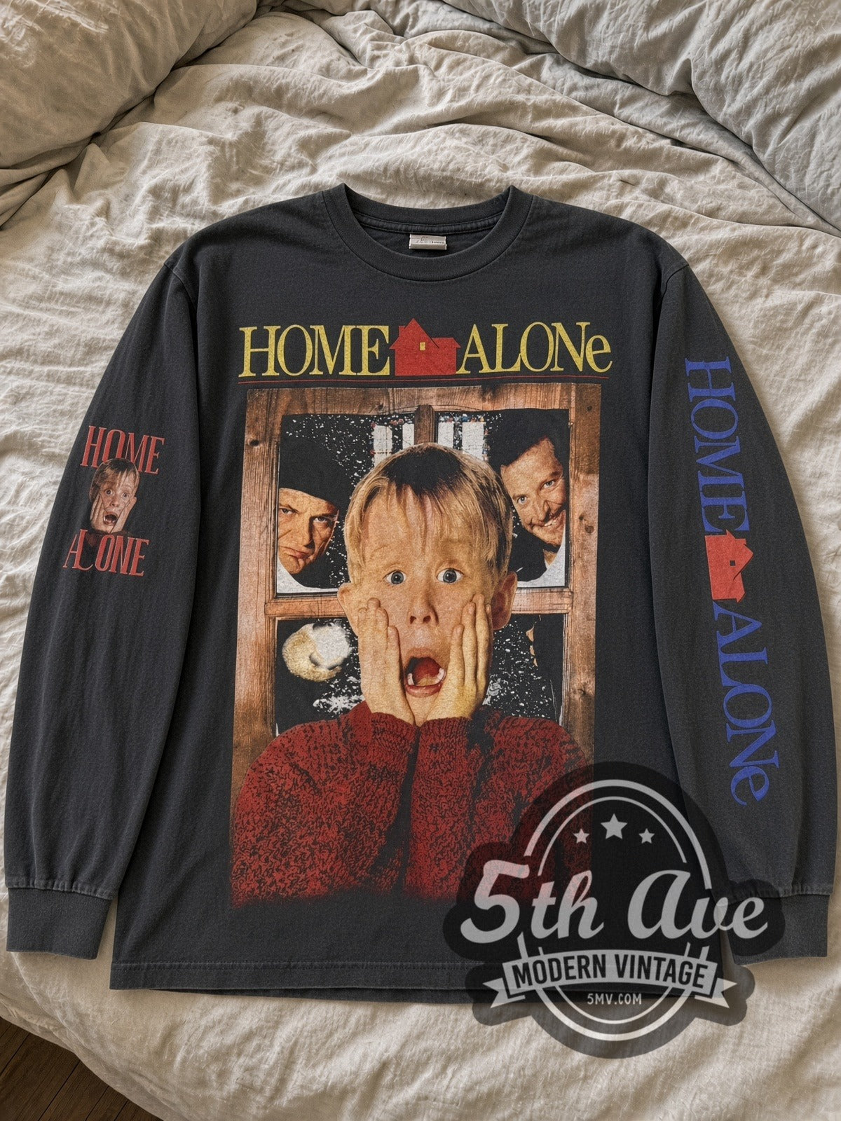 Faded black Home Alone Kevin scream long sleeve tee laid flat on linen bed