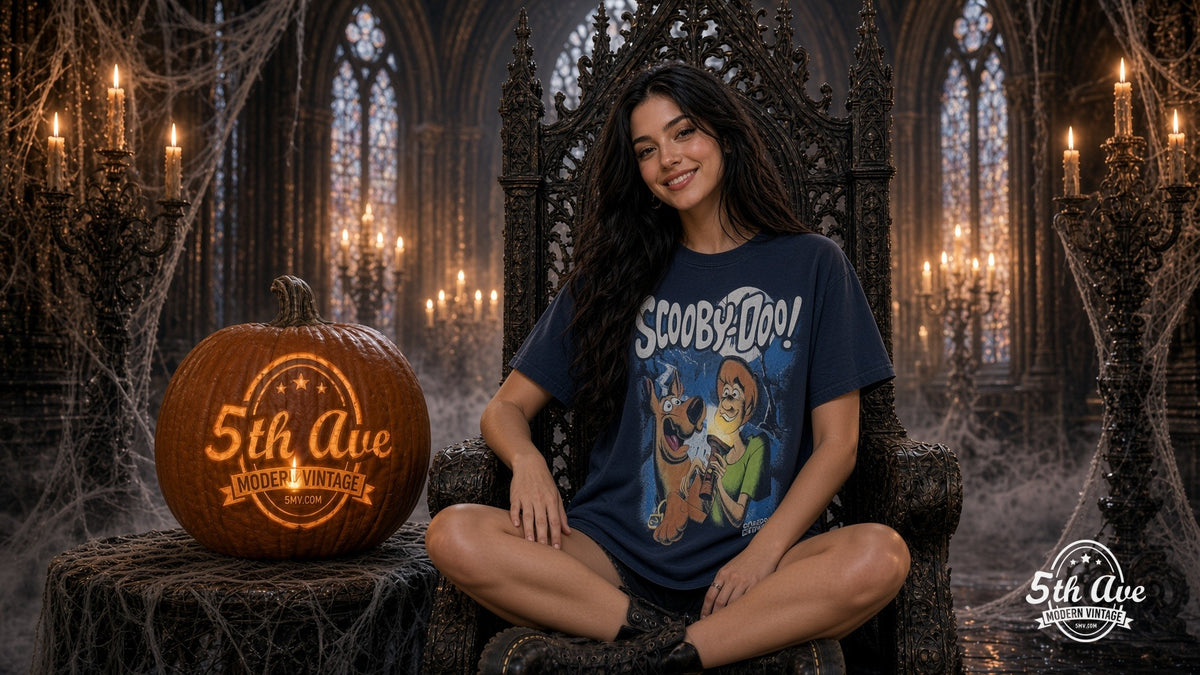 Smiling model in a navy Scooby-Doo Zombie Night tee seated on a gothic throne beside a glowing carved 5th Ave Modern Vintage pumpkin