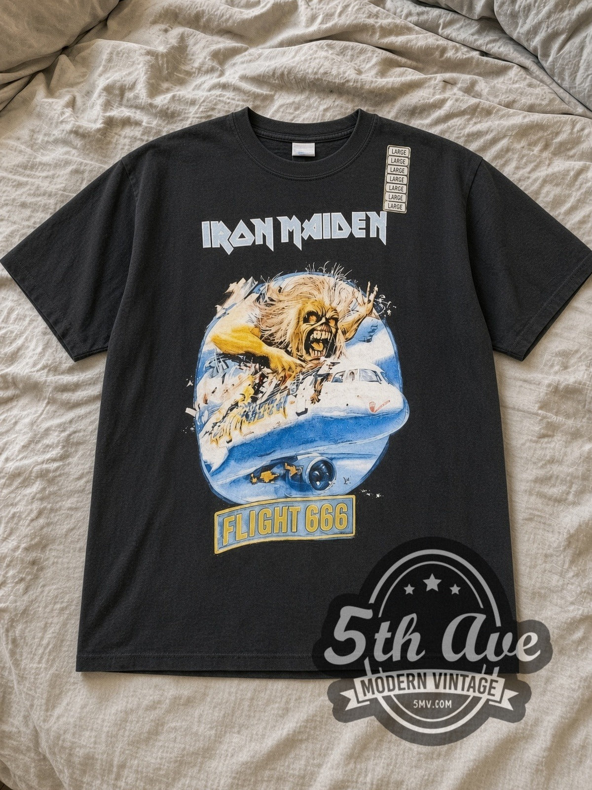Black Iron Maiden Flight 666 Vintage Band T-Shirt laid flat on a linen bed