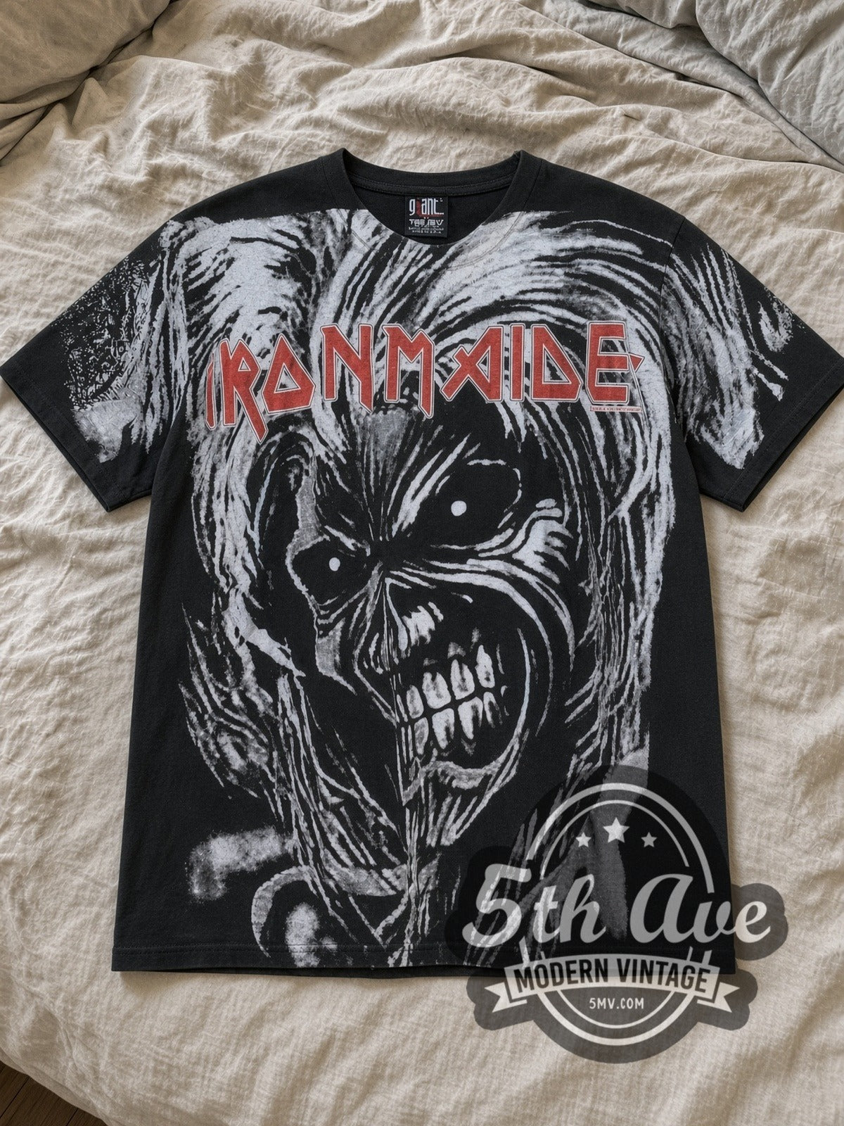 Black Iron Maiden Killers Oversized Debut Eddie Face All Over Print Vintage Band T-Shirt laid flat on a linen bed