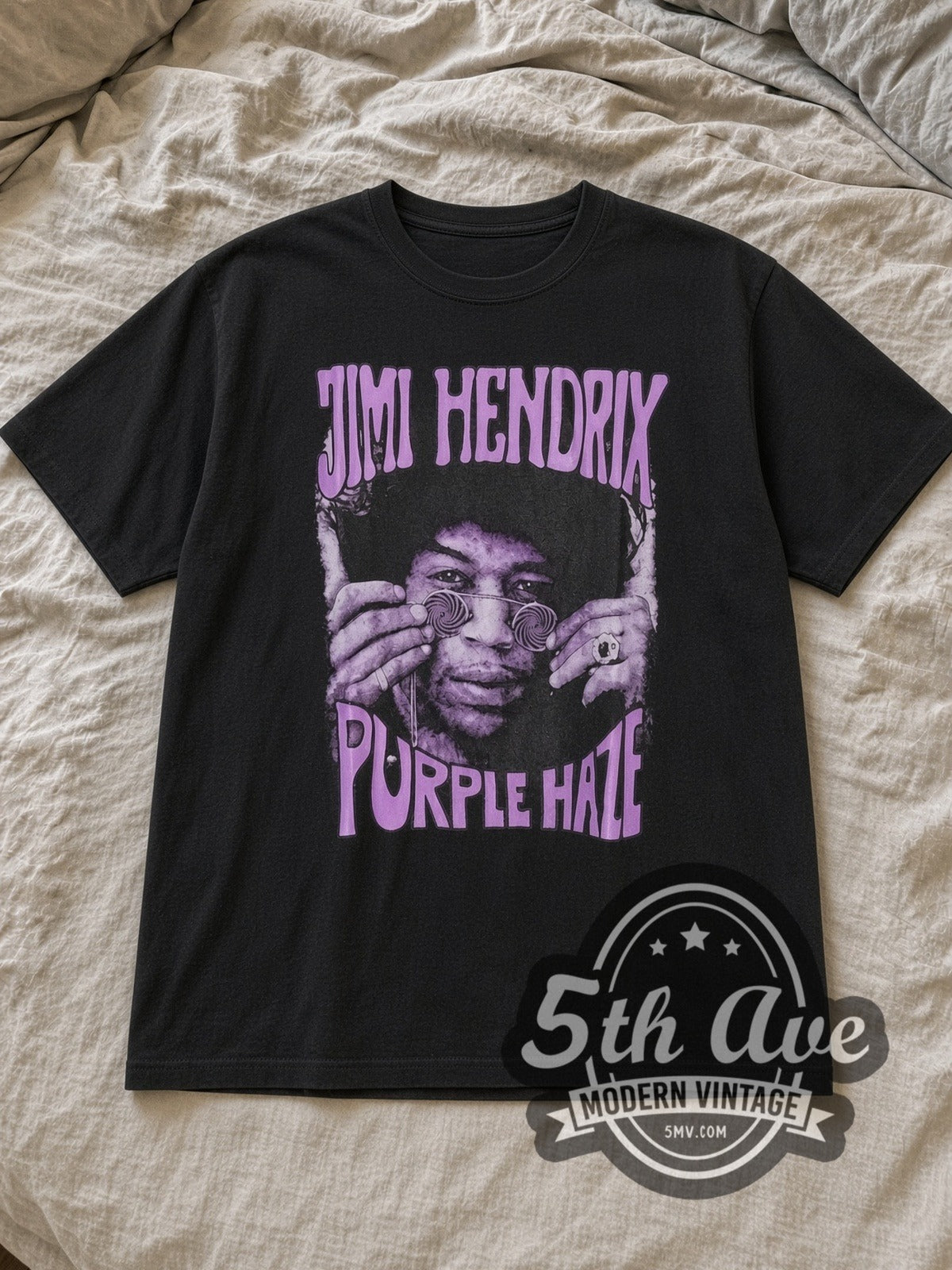 Black Jimi Hendrix Purple Haze Vintage Band T-Shirt laid flat on a linen bed