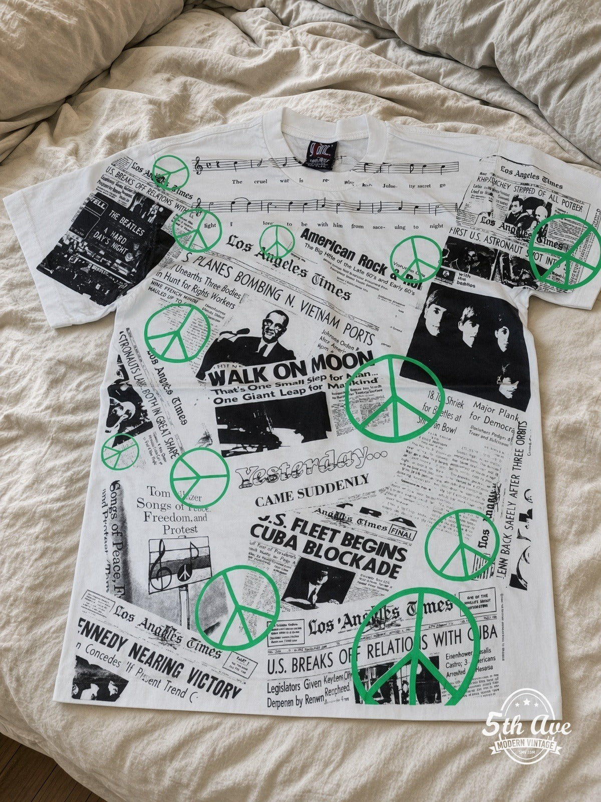 John Lennon War Is Over Newspaper all over print vintage tee laid on bed