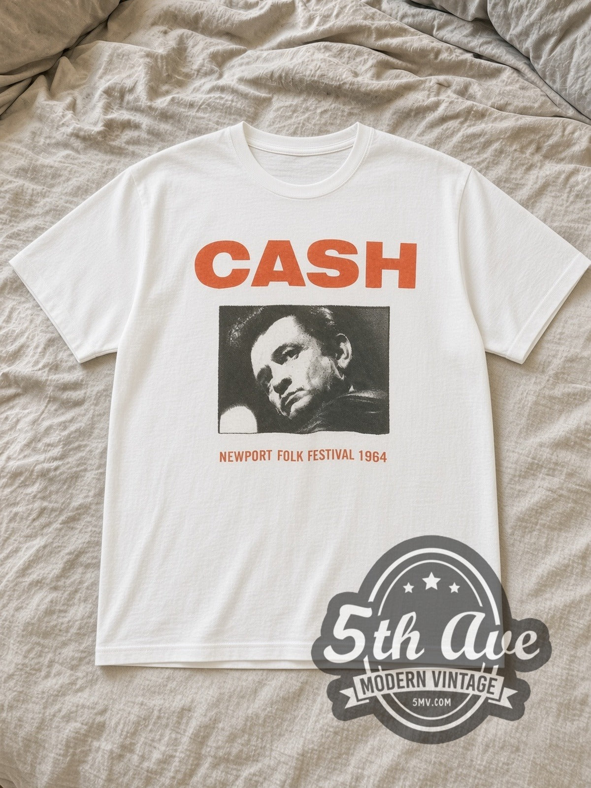 White Johnny Cash Newport Folk Festival 1964 Vintage Band T-Shirt laid flat on a linen bed