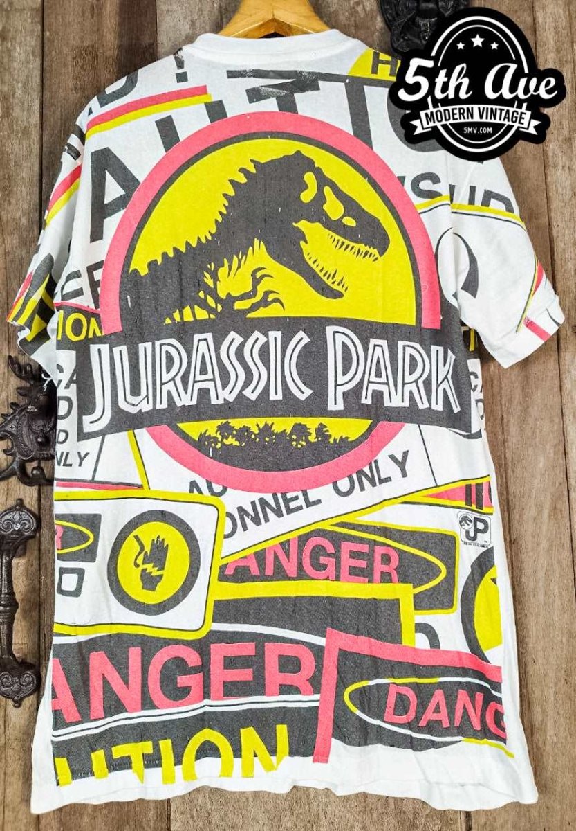 Jurassic Adventure: Distressed Cotton T-Shirt with All-Over Jurassic Park Print and 30-Day Satisfaction Guarantee - Vintage Band Shirts