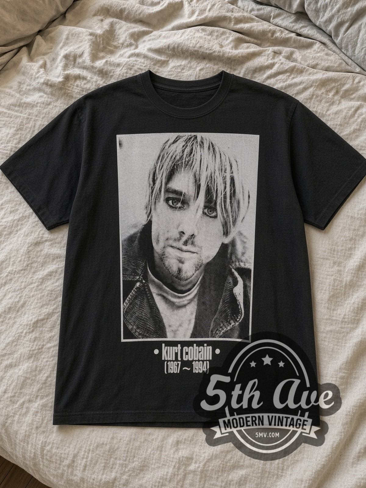 Black Kurt Cobain Memorial Vintage Band T-Shirt laid flat on a linen bed