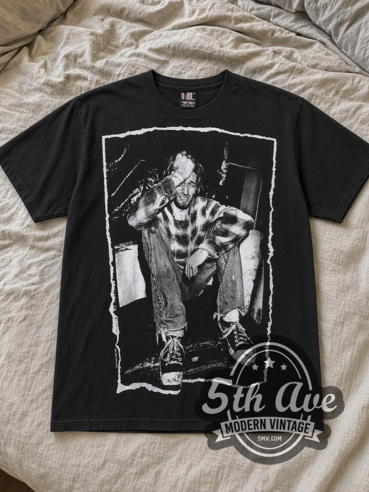 Black Kurt Cobain Nirvana AOP All Over Print Vintage Band T-Shirt laid flat on a linen bed