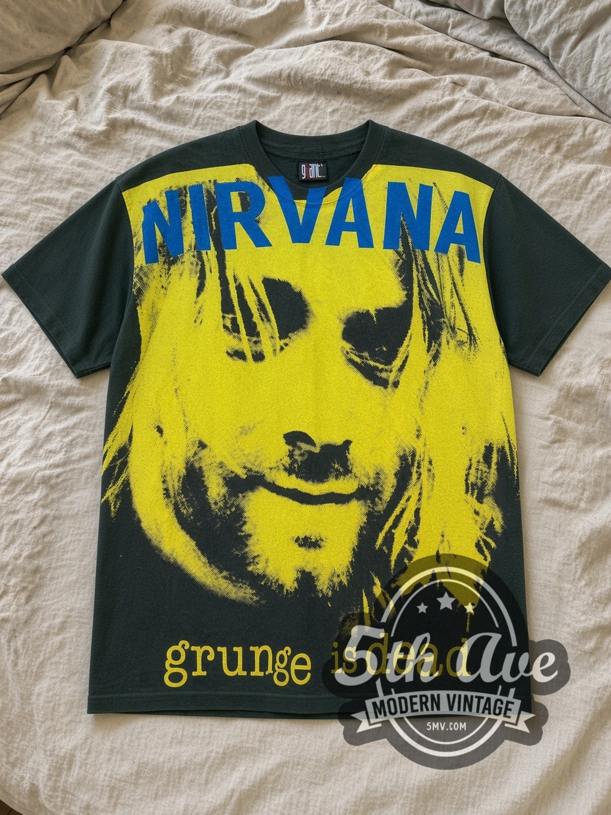 Green Nirvana Grunge Is Dead All Over Print Vintage Band T-Shirt laid flat on a linen bed