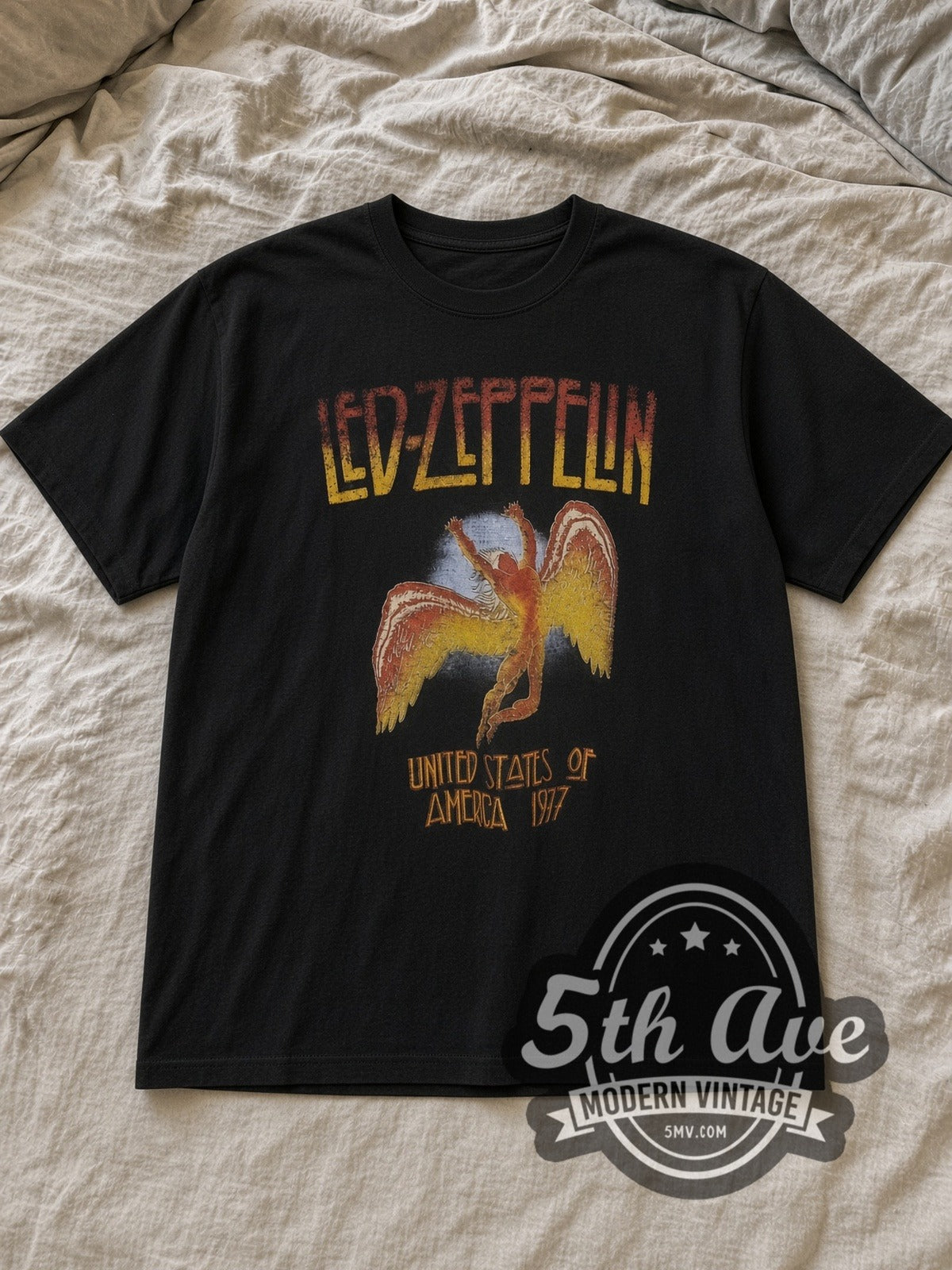 Black Led Zeppelin Icarus Vintage Band T-Shirt laid flat on a linen bed