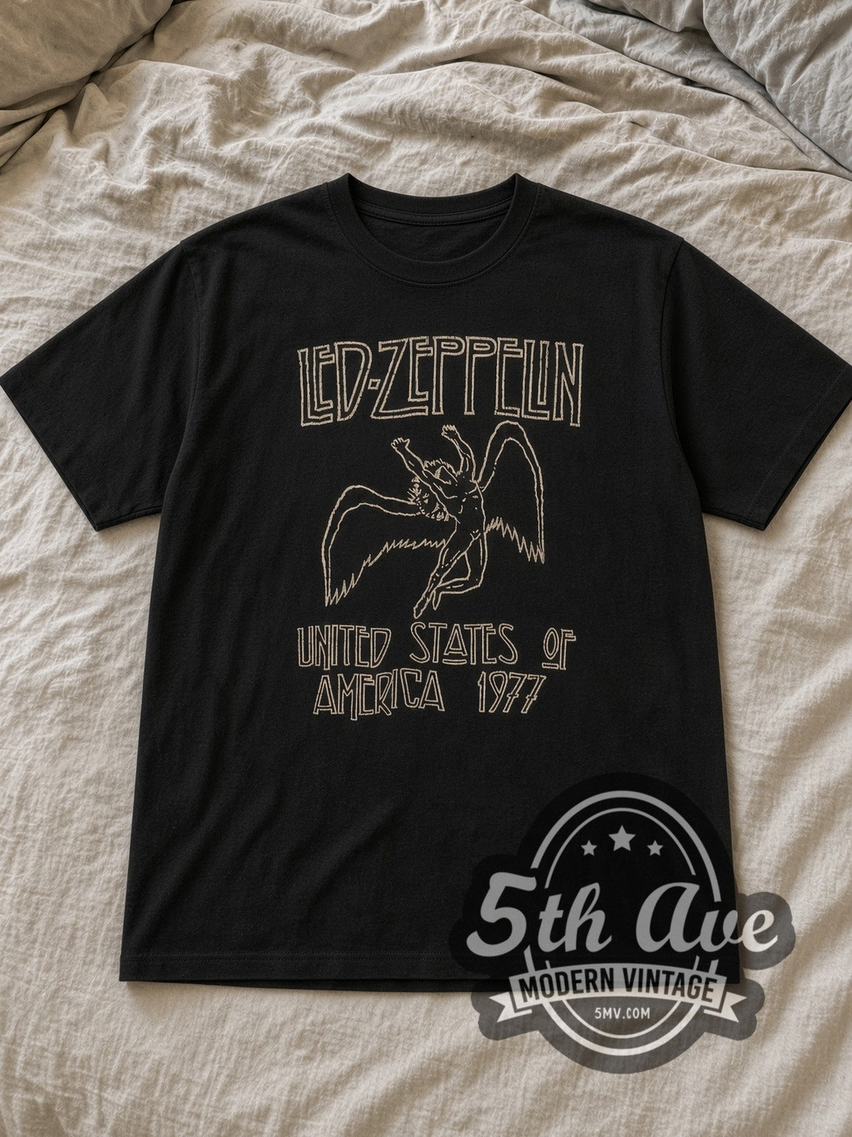 Black Led Zeppelin USA 1977 Icarus Logo Vintage Band T-Shirt laid flat on a linen bed