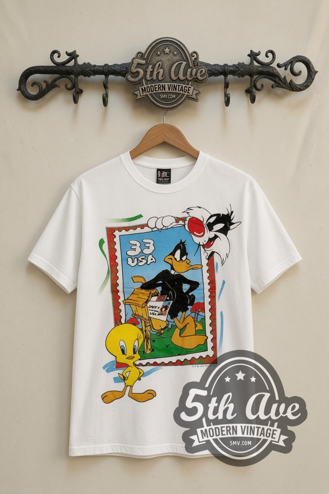 Looney Tunes 33 USA Stamp Tweety Sylvester cartoon tee in white, front view on a display rack
