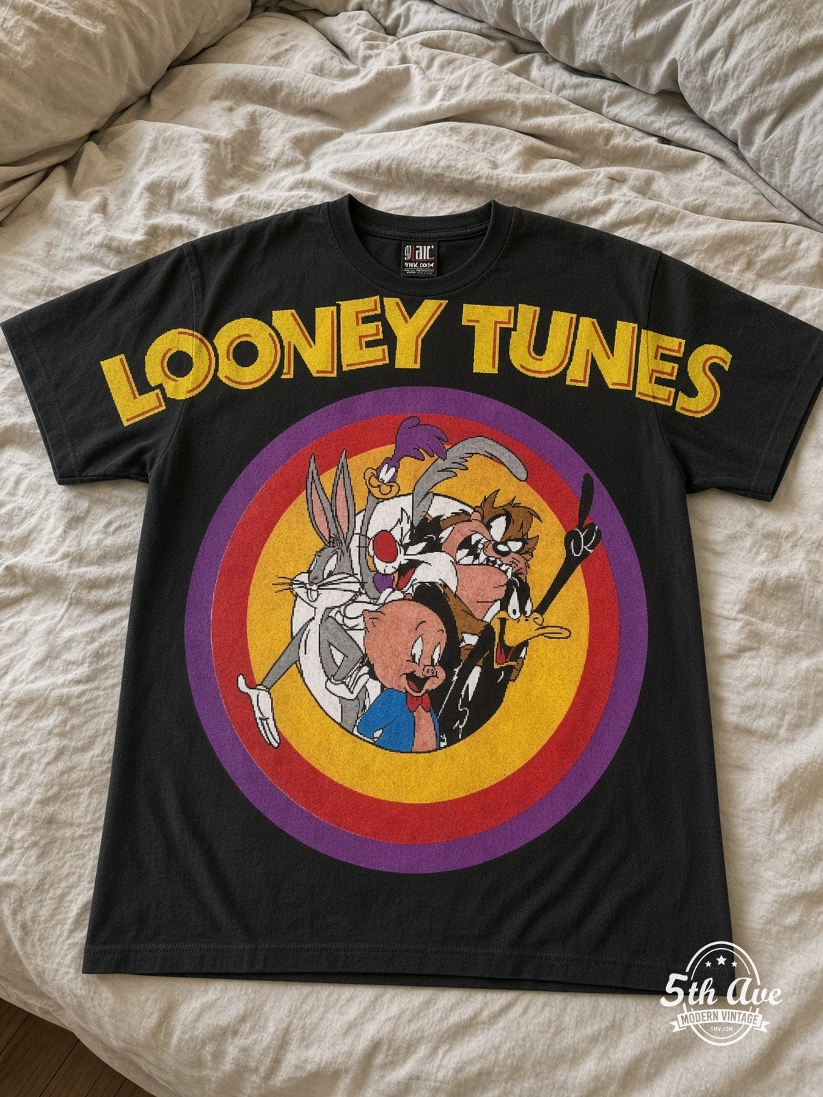Looney Tunes Circle Badge Group Black vintage tee laid on bed
