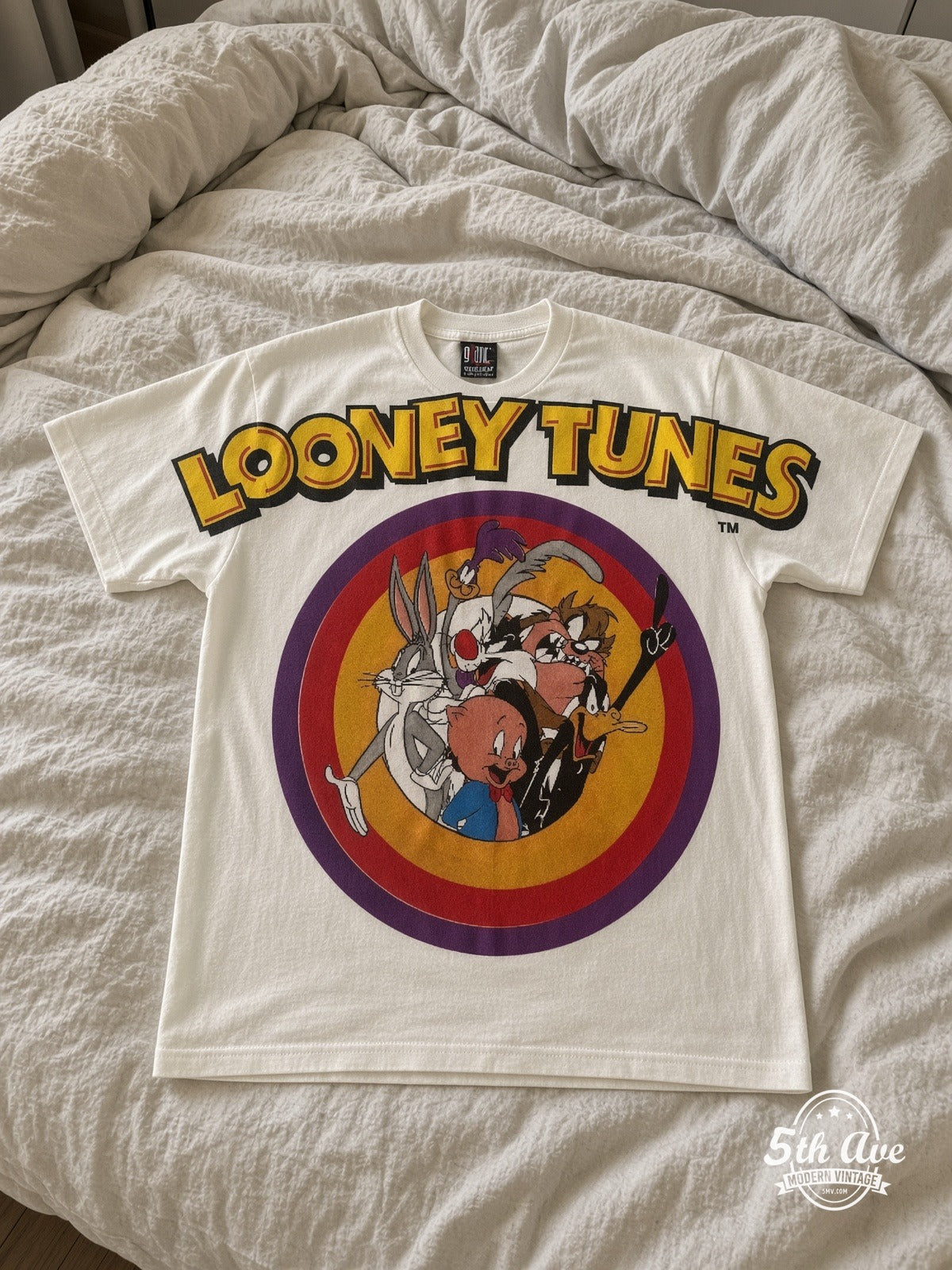 Looney Tunes Circle Badge Group White vintage tee laid on bed