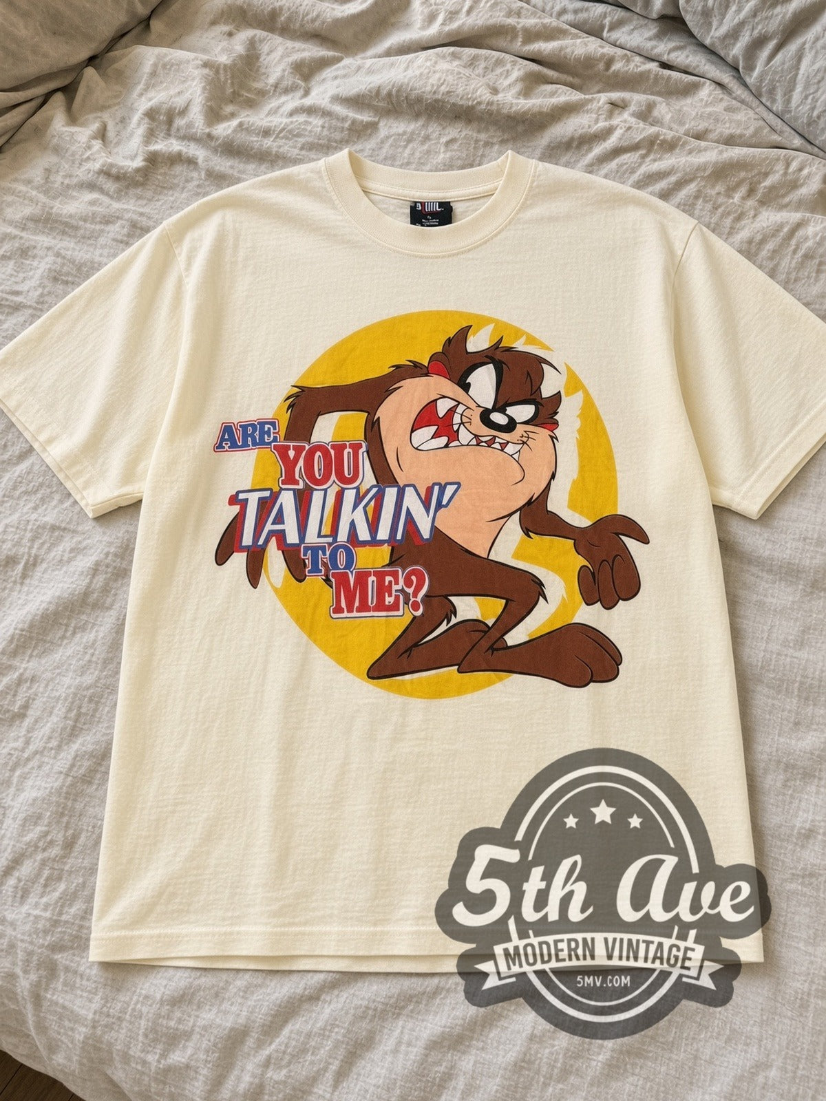 Cream Looney Tunes Taz Are You Talkin' to Me? tee laid flat on linen bed