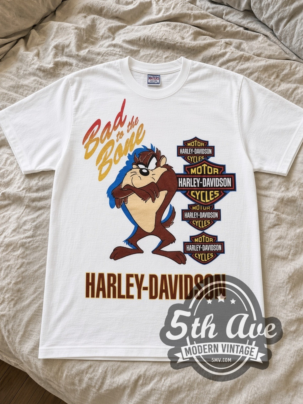 Looney Tunes Taz Bad to the Bone Harley cartoon tee in white laid flat on a bed, front artwork