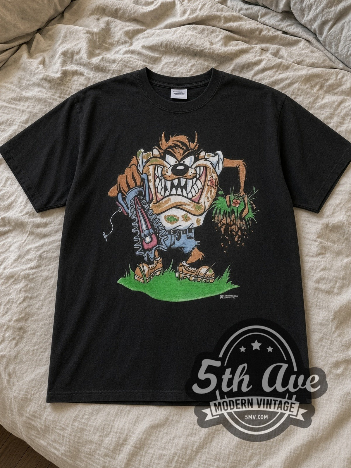 Black Looney Tunes Taz Mania Landscaping Vintage Cartoon T-Shirt laid flat on a linen bed