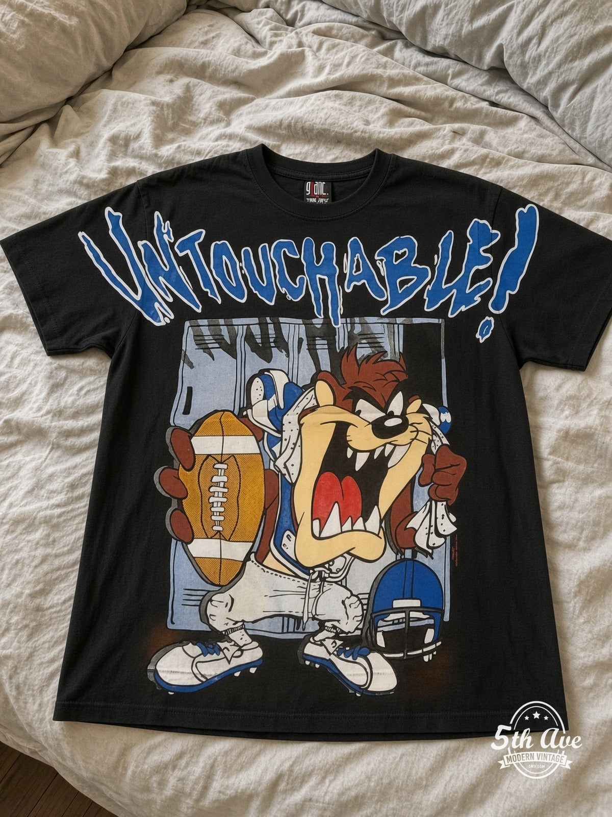 Looney Tunes Taz Untouchable Football vintage tee laid on bed
