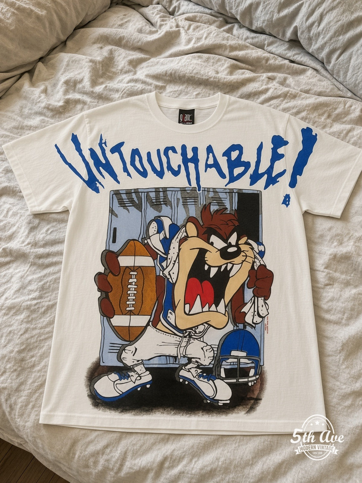 Looney Tunes Taz Untouchable Football vintage tee laid on bed
