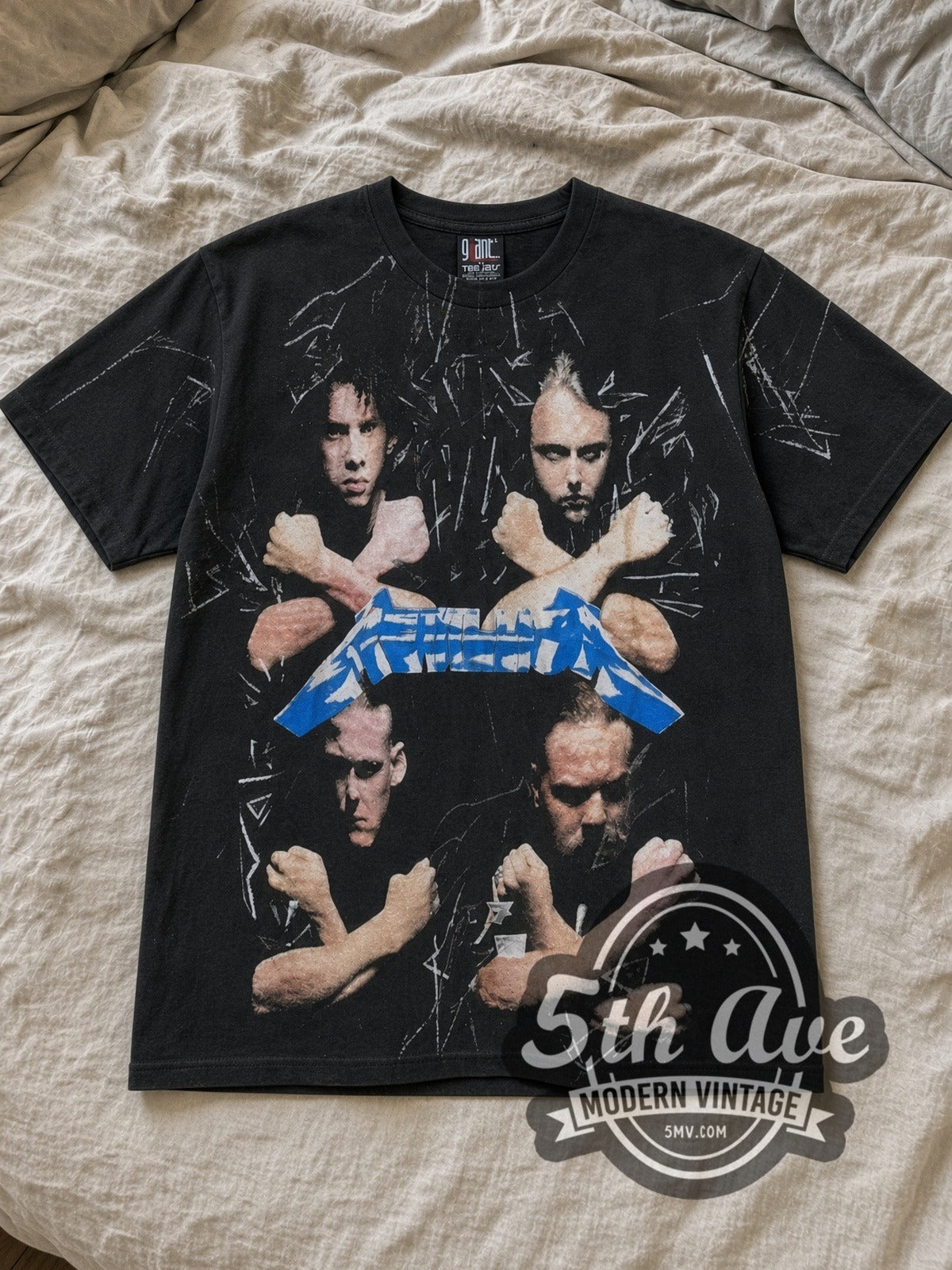 Black Metallica Unleash the Metal All Over Print Vintage Band T-Shirt laid flat on a linen bed