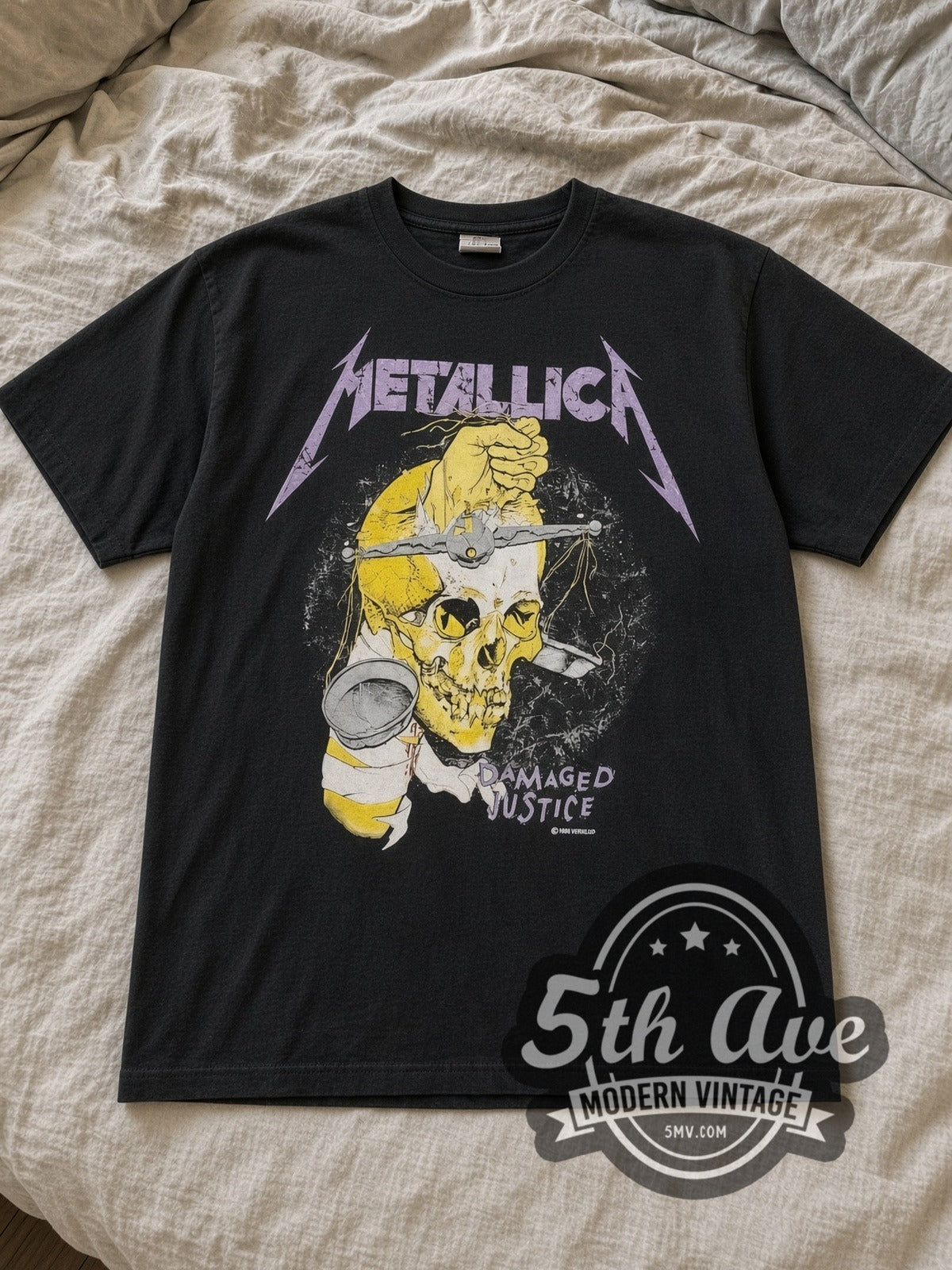 Black Metallica Damaged Justice Hammer of Justice Crushes You Vintage Band T-Shirt laid flat on a linen bed