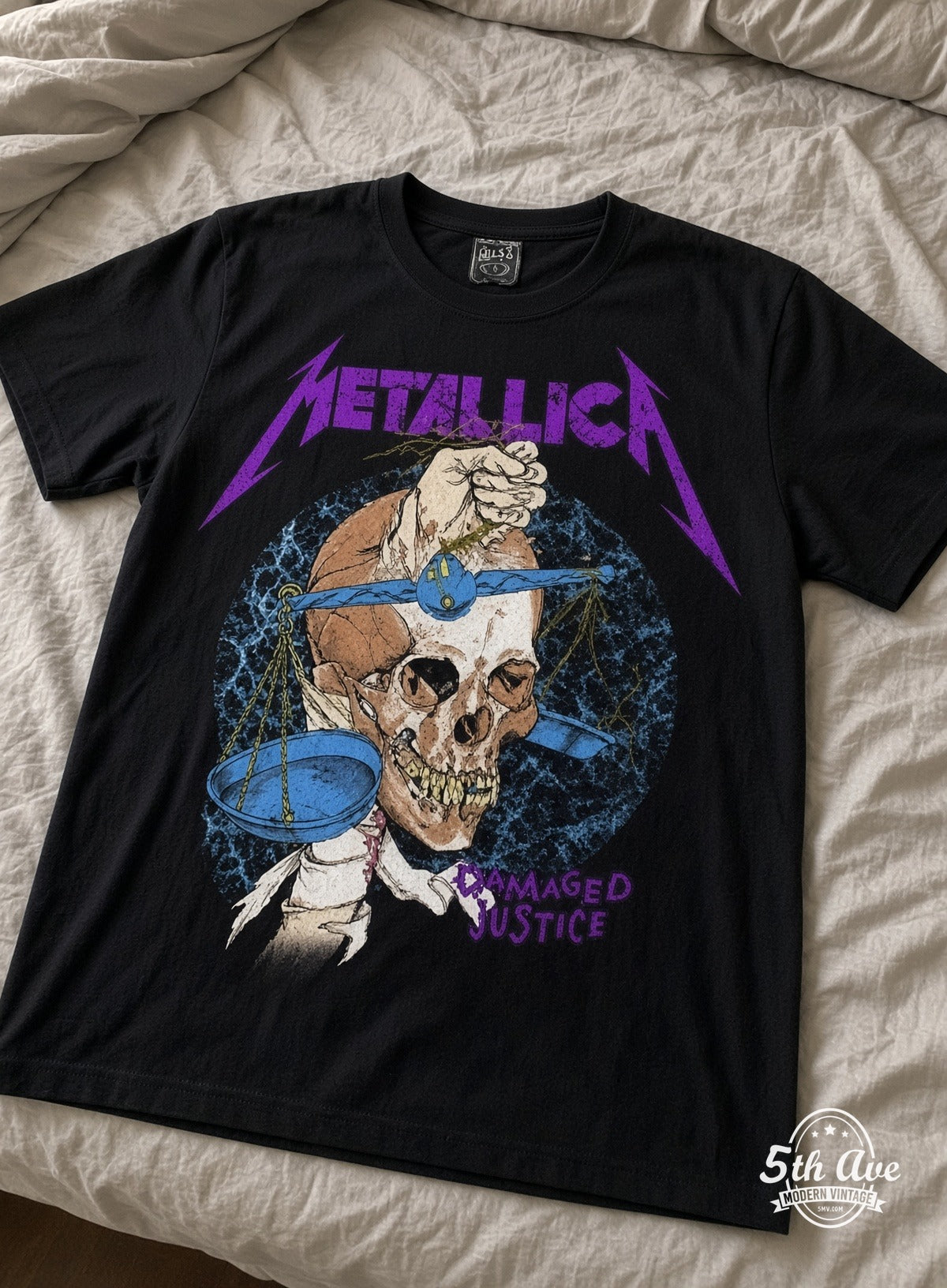 Metallica Damaged Justice vintage t-shirt laid on bed