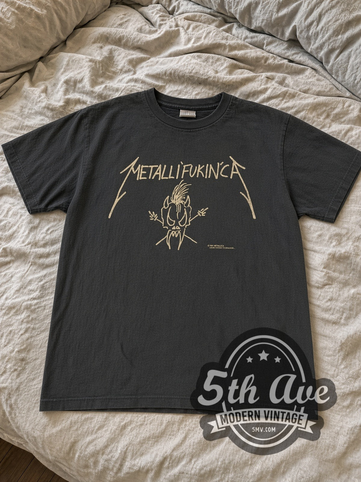 Faded black Metallifukinca Scary Guy tee laid flat on linen bed