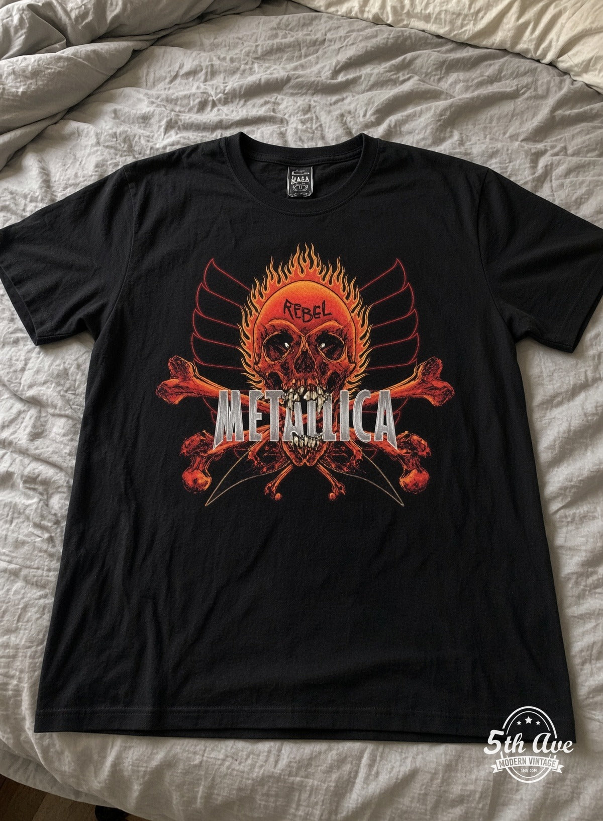Metallica Rebel flaming skull vintage t-shirt laid on bed