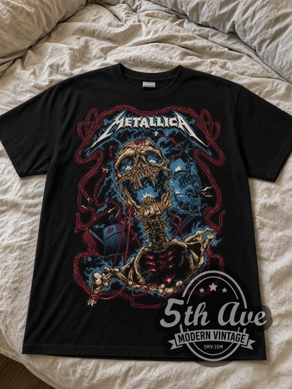 Metallica Skeleton Rising black graphic tee laid flat on linen bed