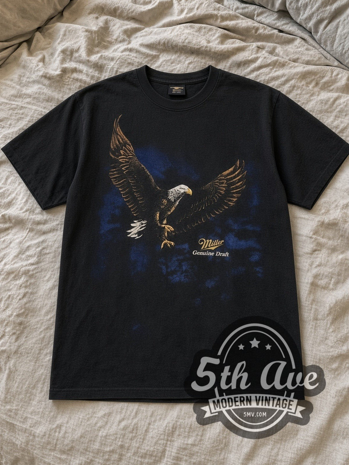 Black Miller Genuine Draft Vintage Graphic T-Shirt laid flat on a linen bed