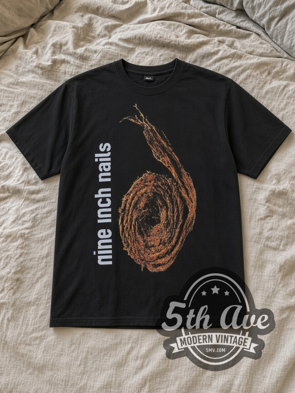 Black Nine Inch Nails Further Down the Spiral Vintage Band T-Shirt laid flat on a linen bed