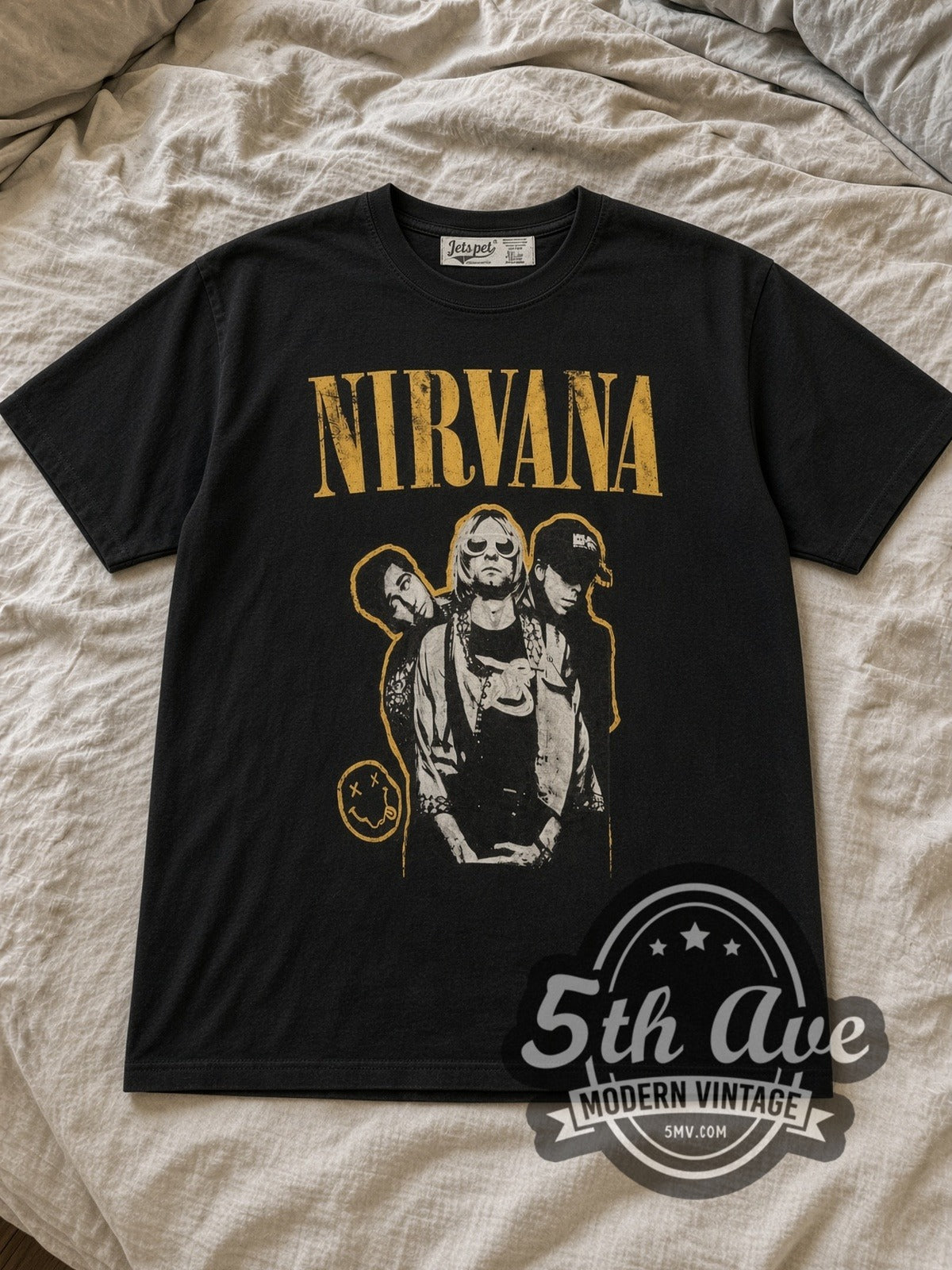 Black Nirvana Yellow Logo Smiley Band Photo Vintage Band T-Shirt laid flat on a linen bed