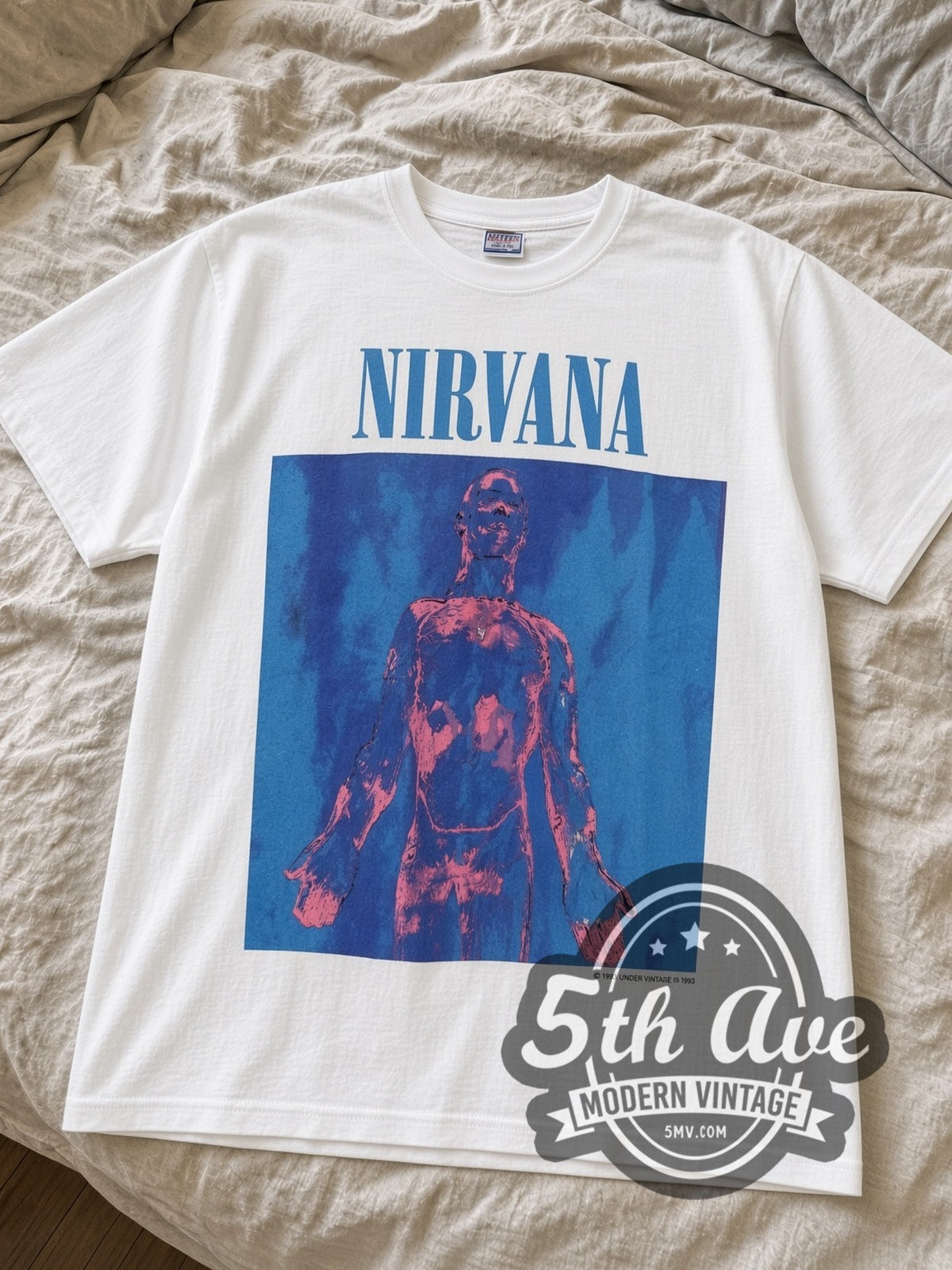 Nirvana Sliver vintage band t-shirt in white laid flat on a bed, showing the blue Sliver album art print
