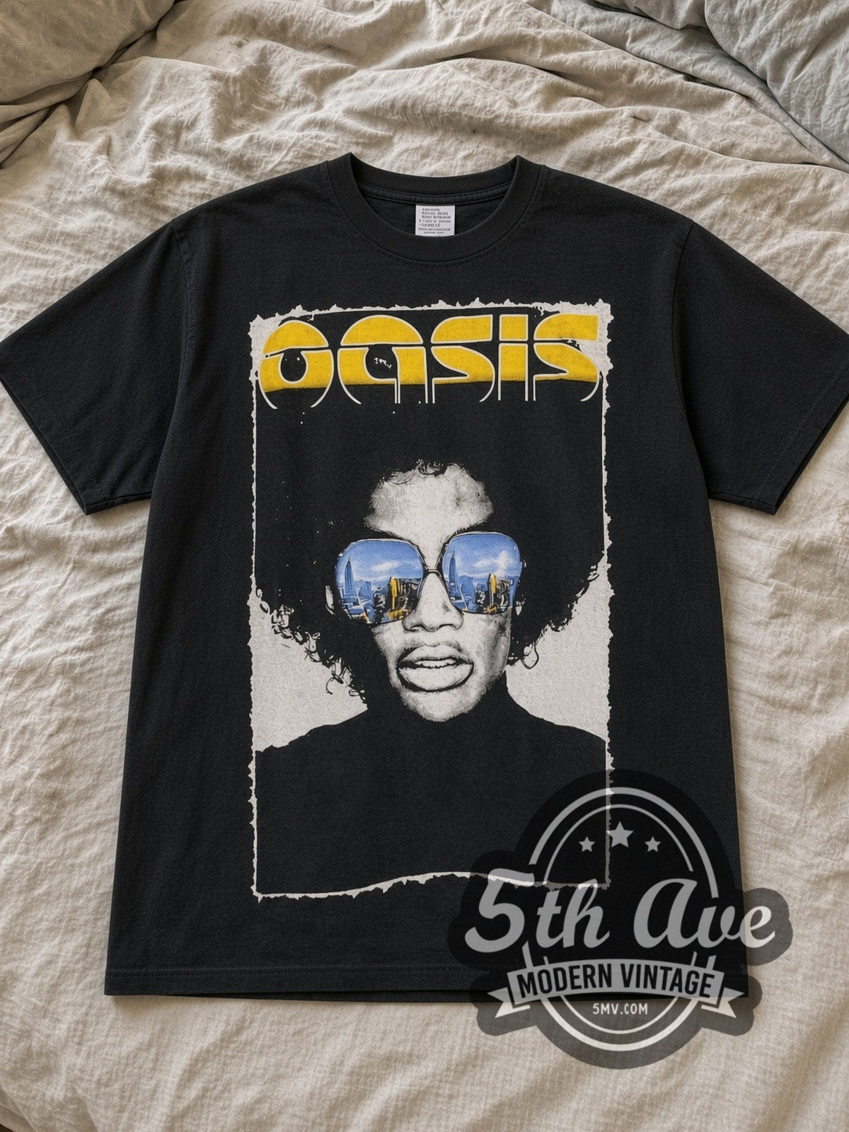 Black Oasis Finsbury Park 2002 with The Charlatans, BRMC, Proud Mary & The Coral Vintage Band T-Shirt laid flat on a linen bed