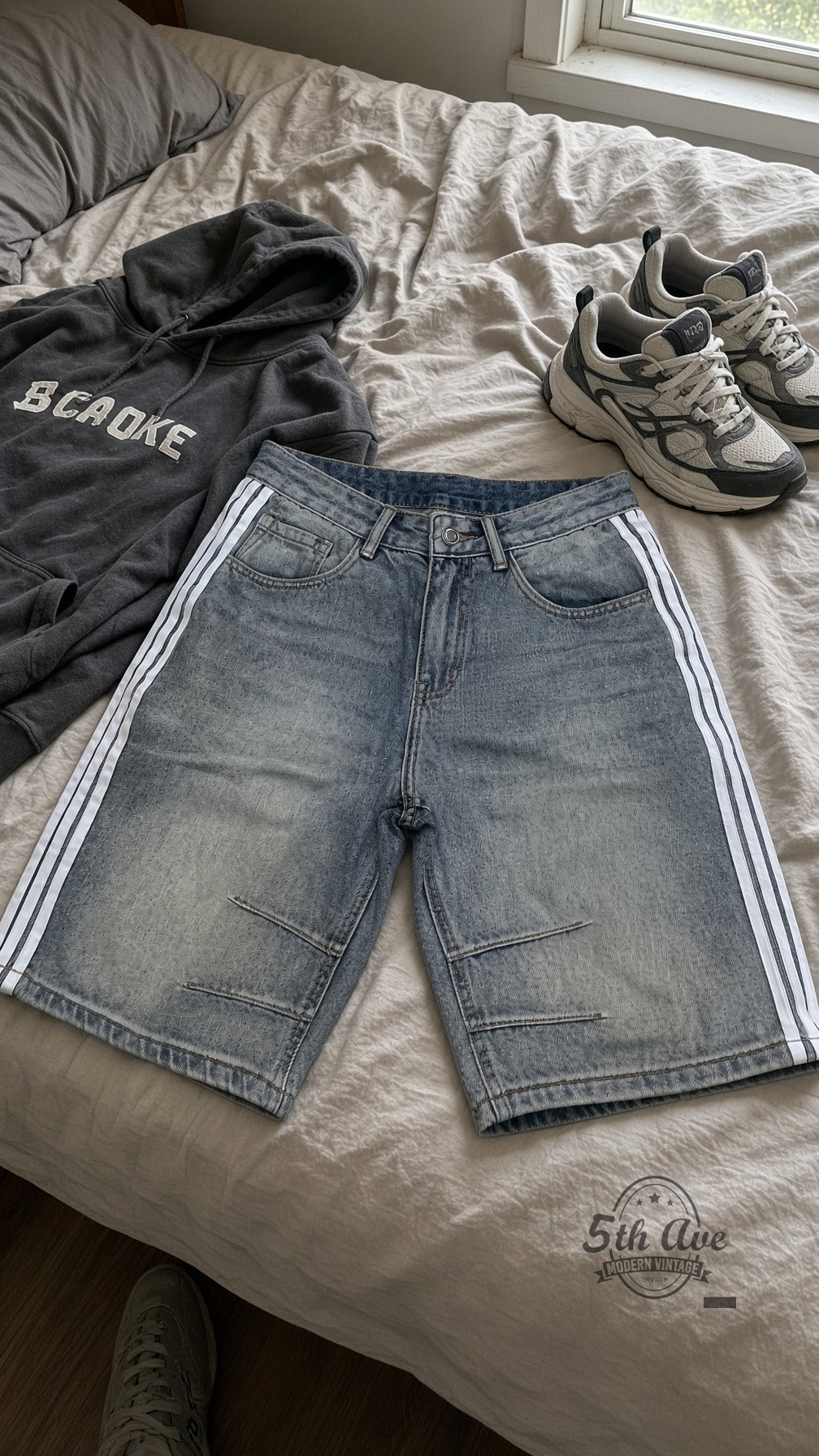Light Wash Side Stripe Pintuck Jorts laid on bed