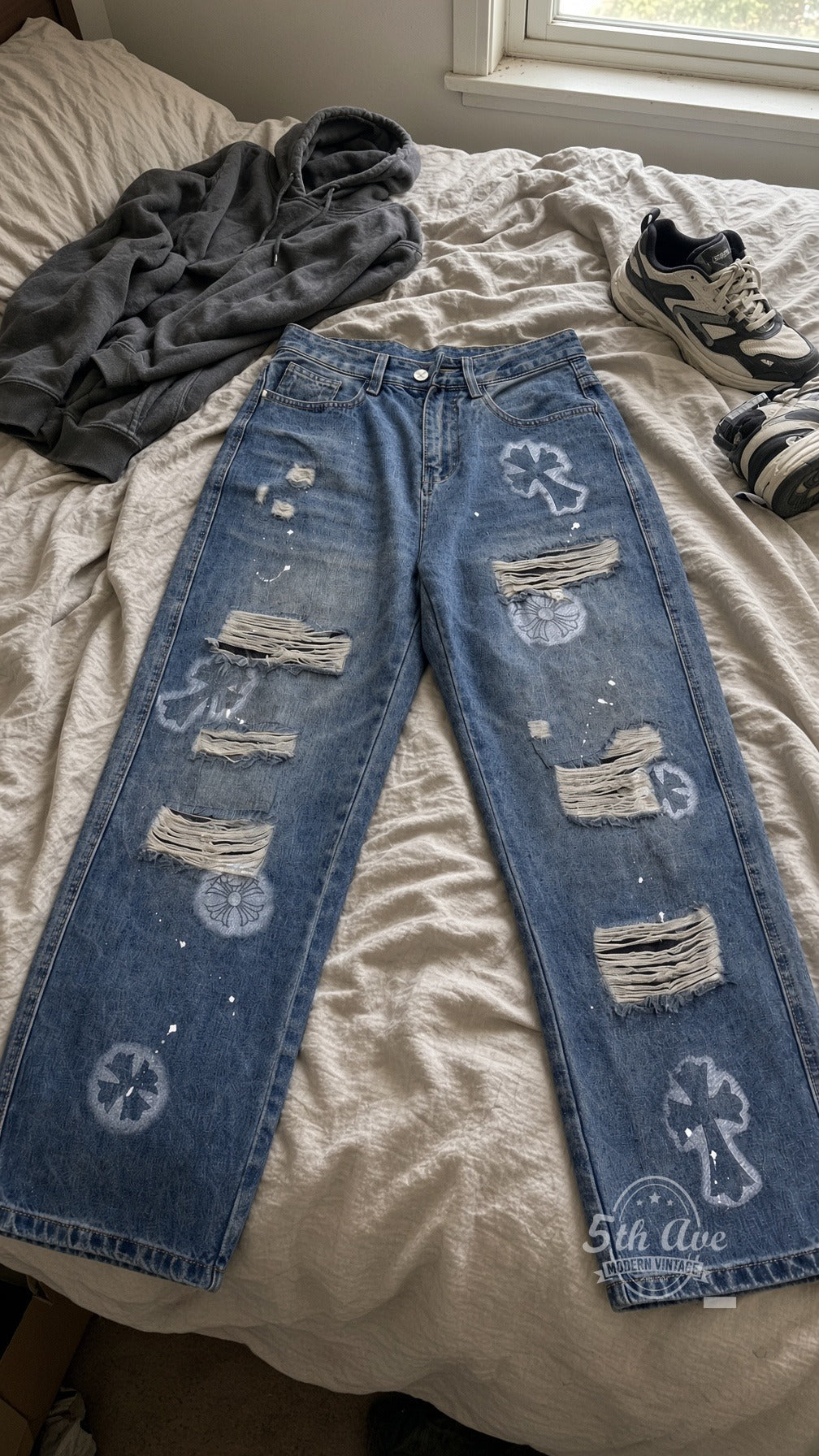 Light Cemetery Cross Floral Distressed Jeans laid on bed
