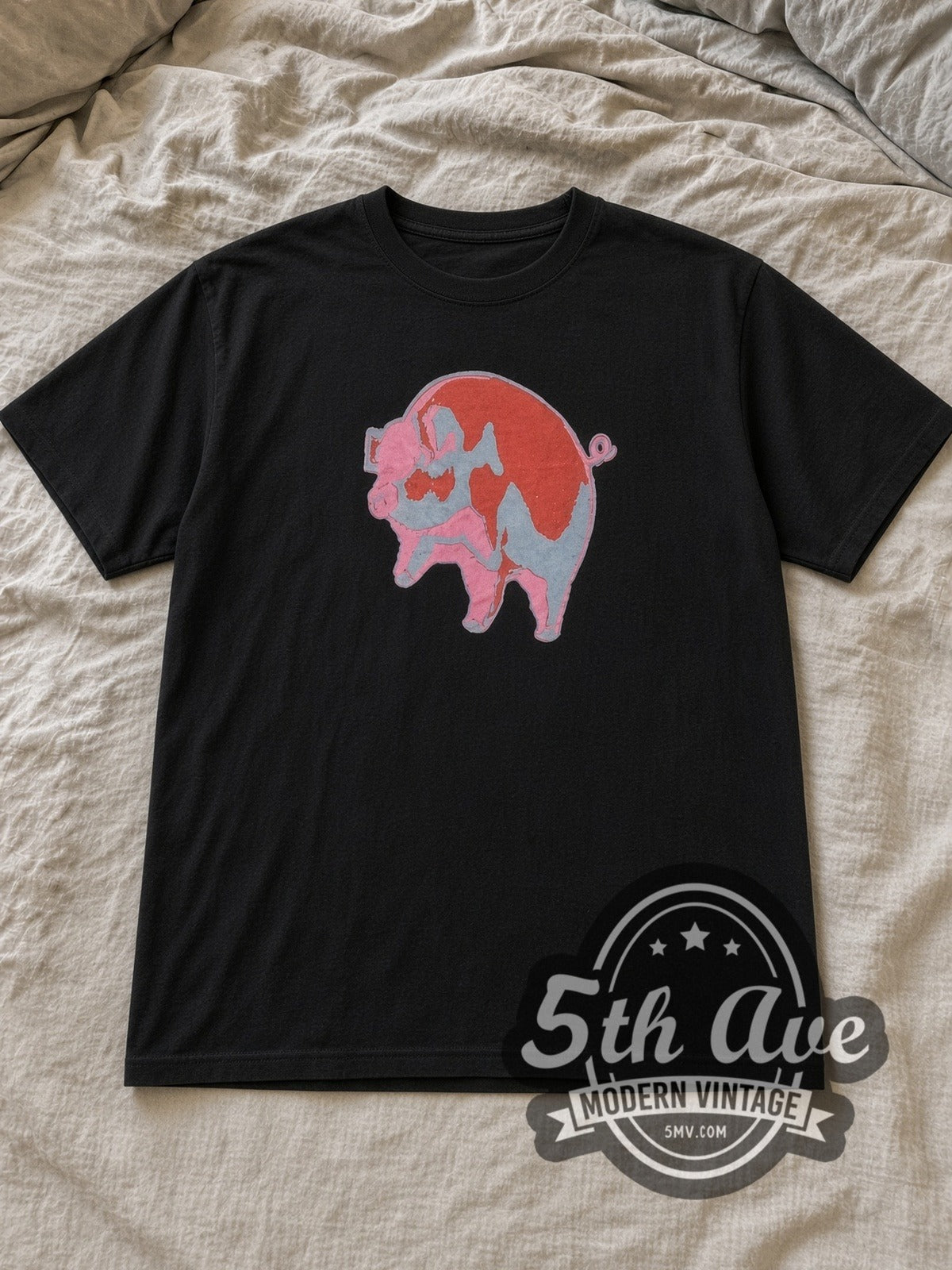 Black Pink Floyd Animals Red Pink Blue Pig Vintage Band T-Shirt laid flat on a linen bed