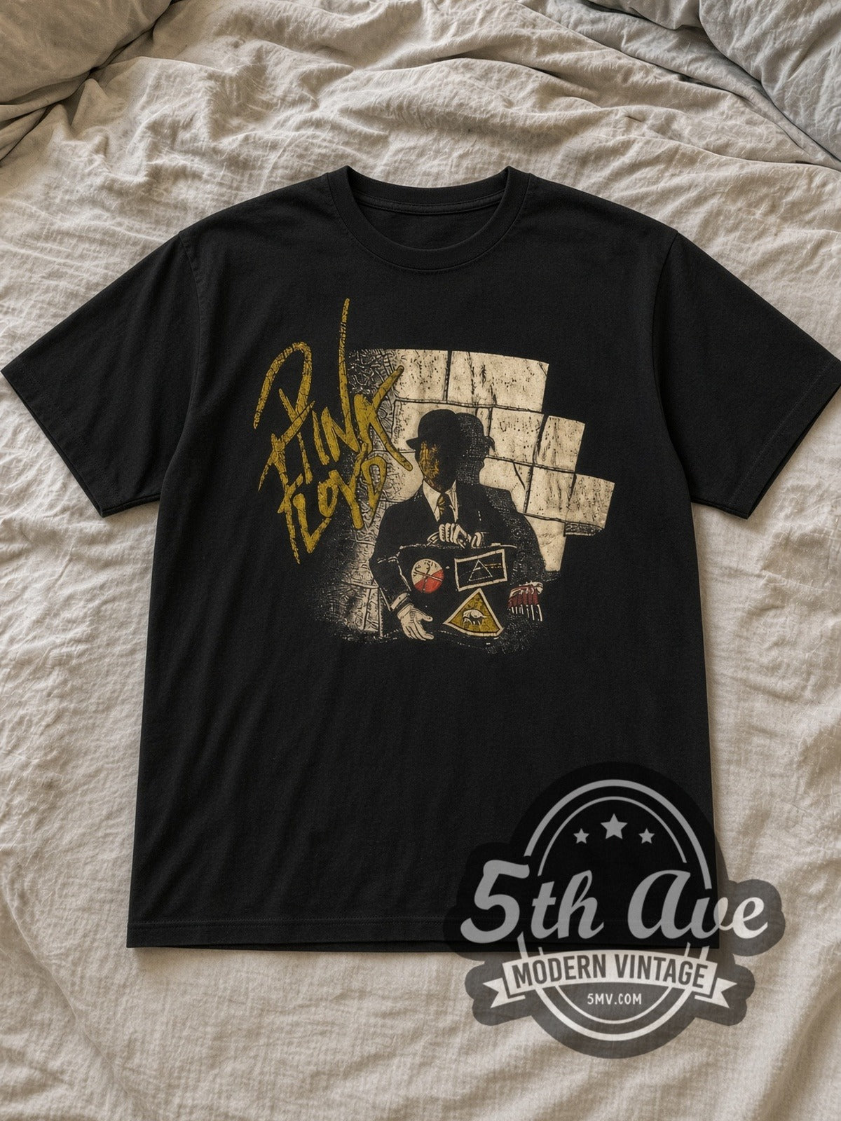 Black Pink Floyd Wall and Derby Figure Vintage Band T-Shirt laid flat on a linen bed