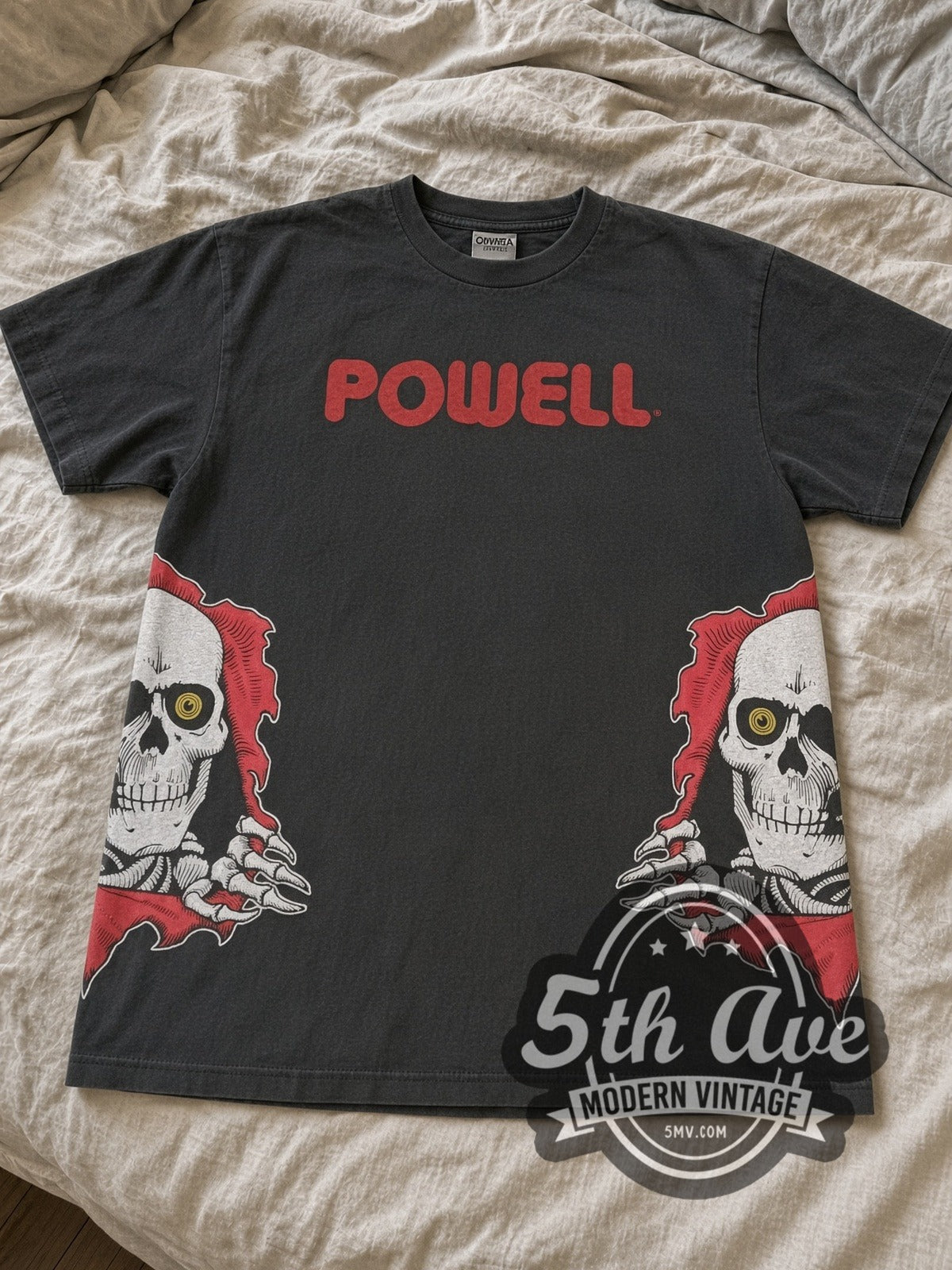 Faded black Powell Peralta Ripper skull tee laid flat on linen bed