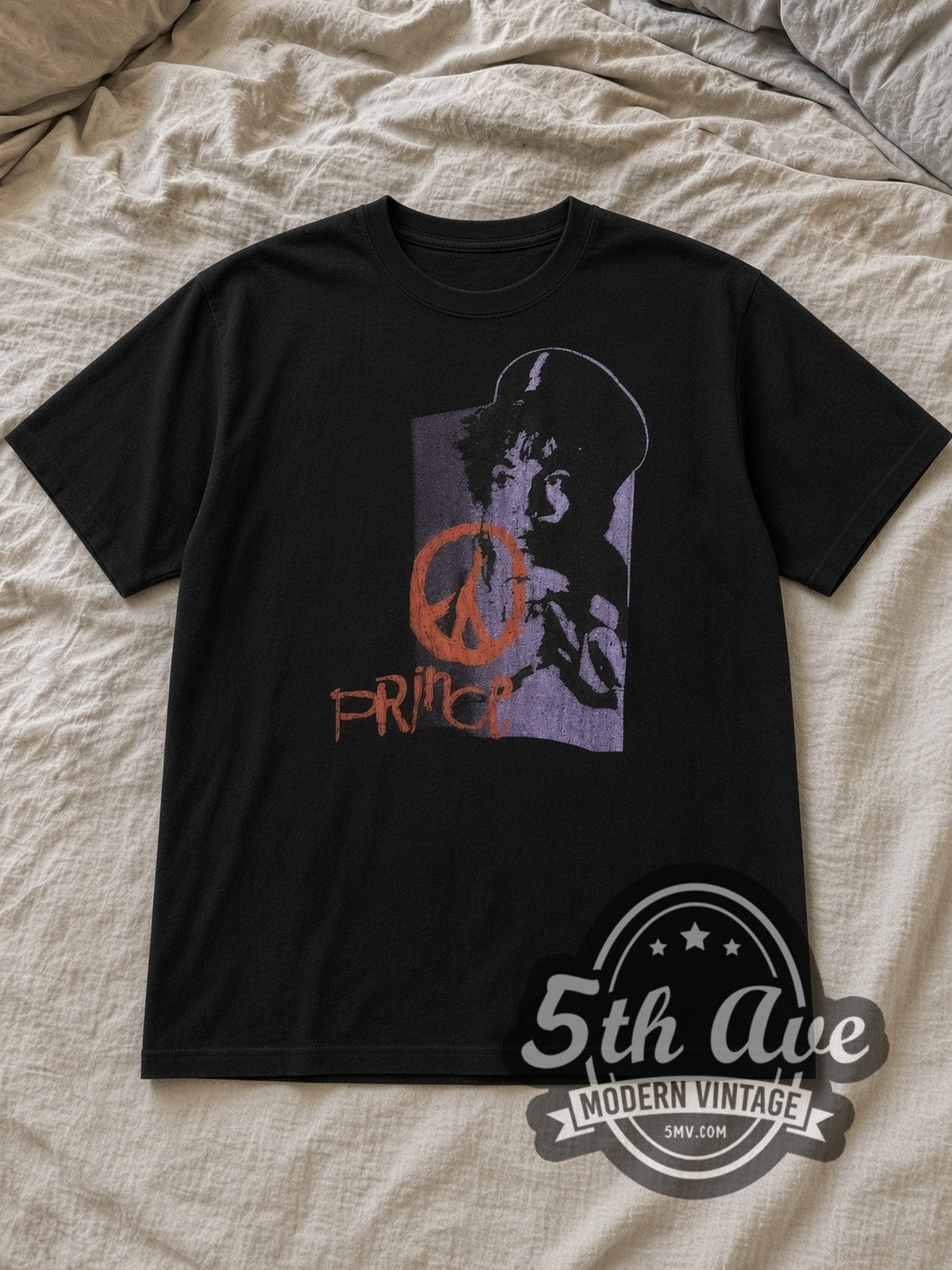 Black Prince Purple Portrait Orange Peace Sign Vintage Band T-Shirt laid flat on a linen bed